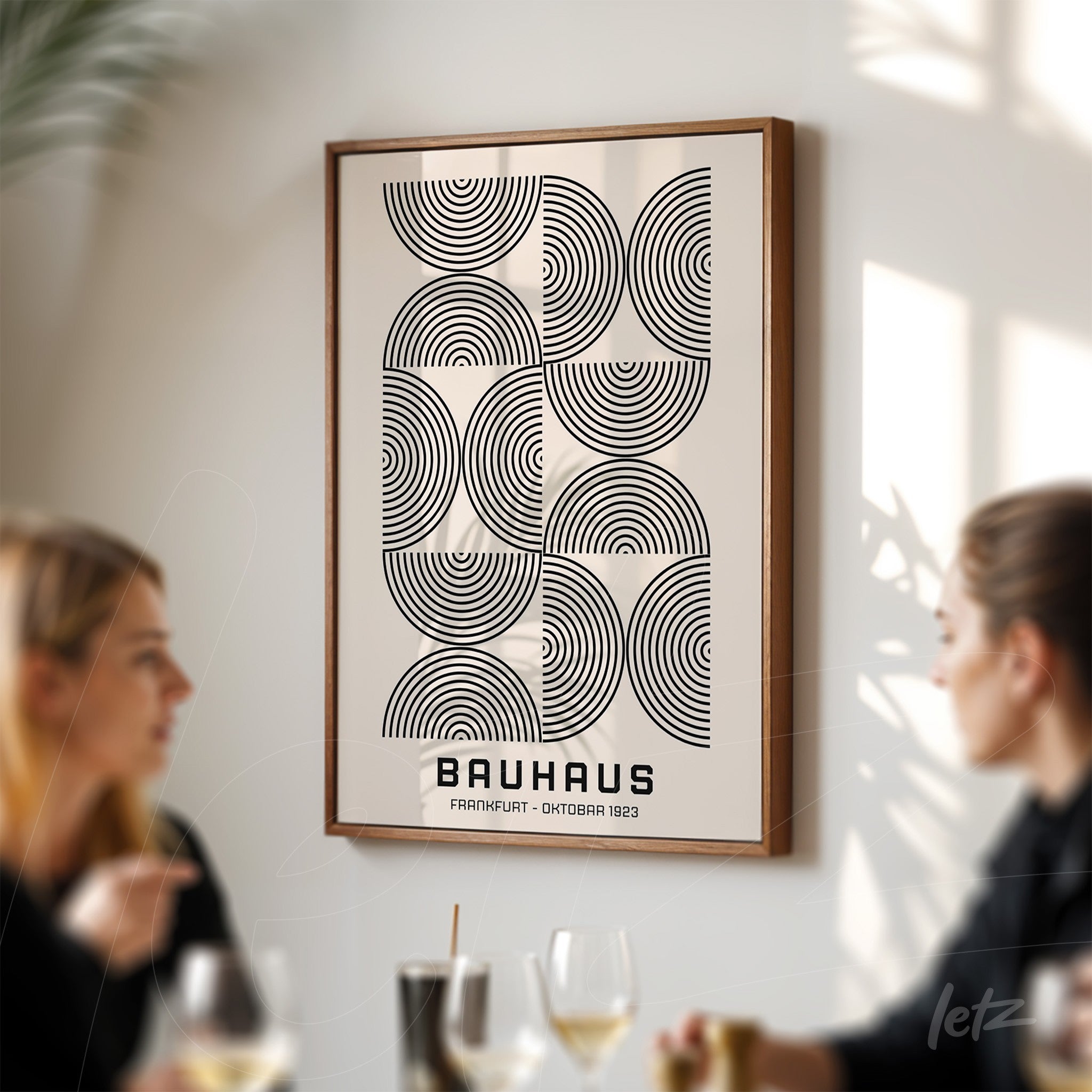 framed geometric black and white bauhaus style art displayed on light-colored wall