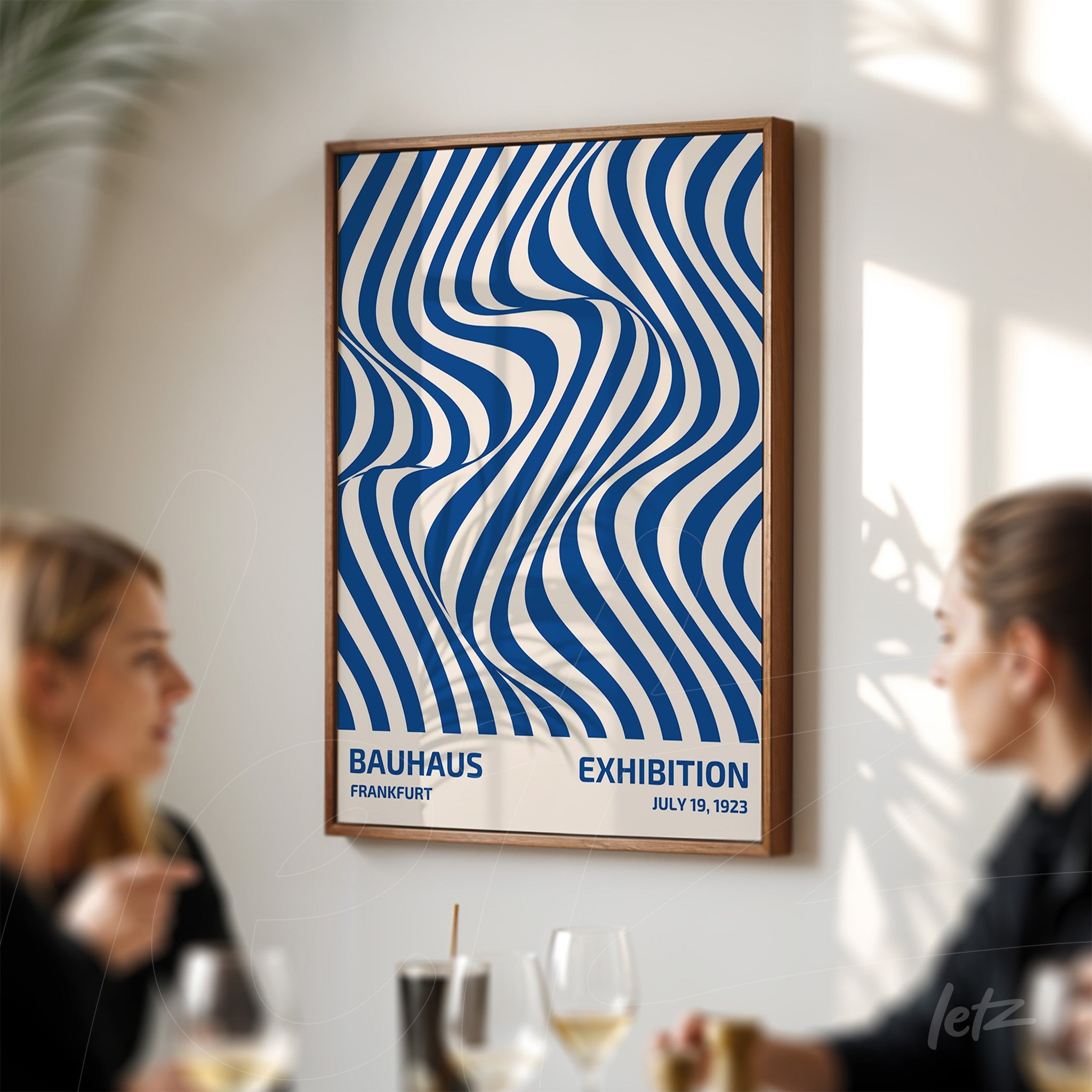 poster with blue and white wavy pattern in dark frame, displayed on white wall