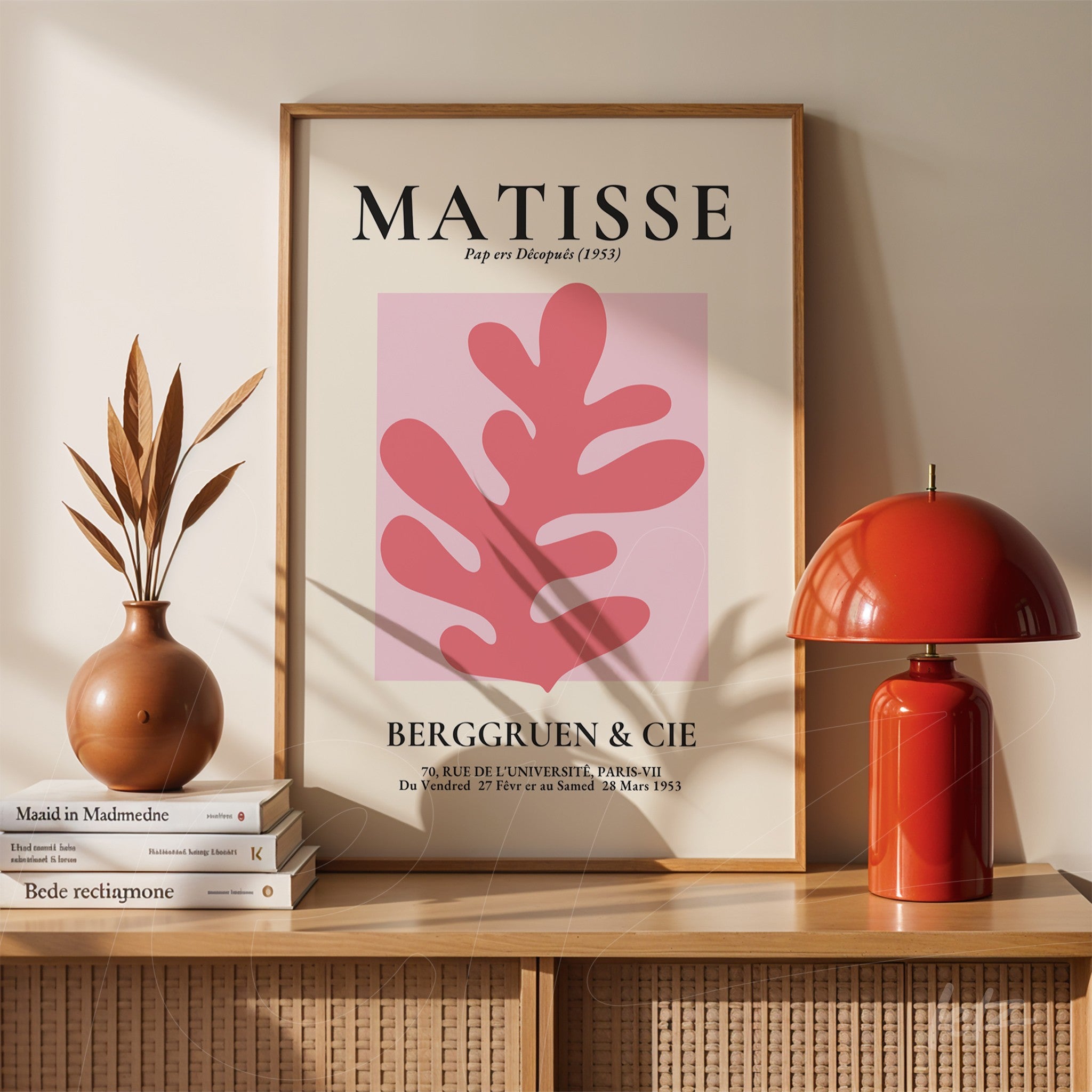 modern decorative wall art featuring pink abstract shapes in light frame, displayed on wooden shelf next to ceramic vase and red lamp
