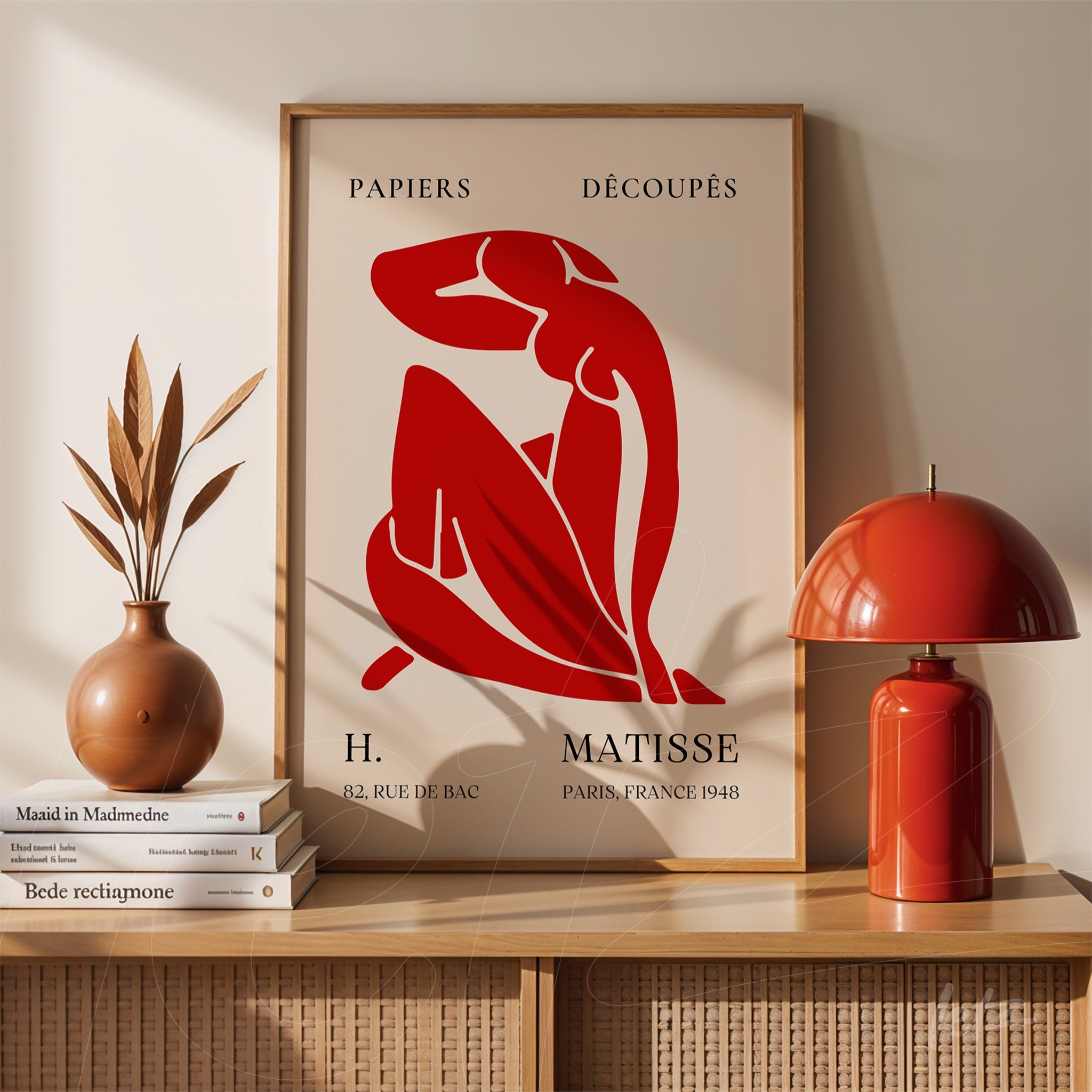 framed artwork featuring red human figures by Henri Matisse displayed on a decorative table
