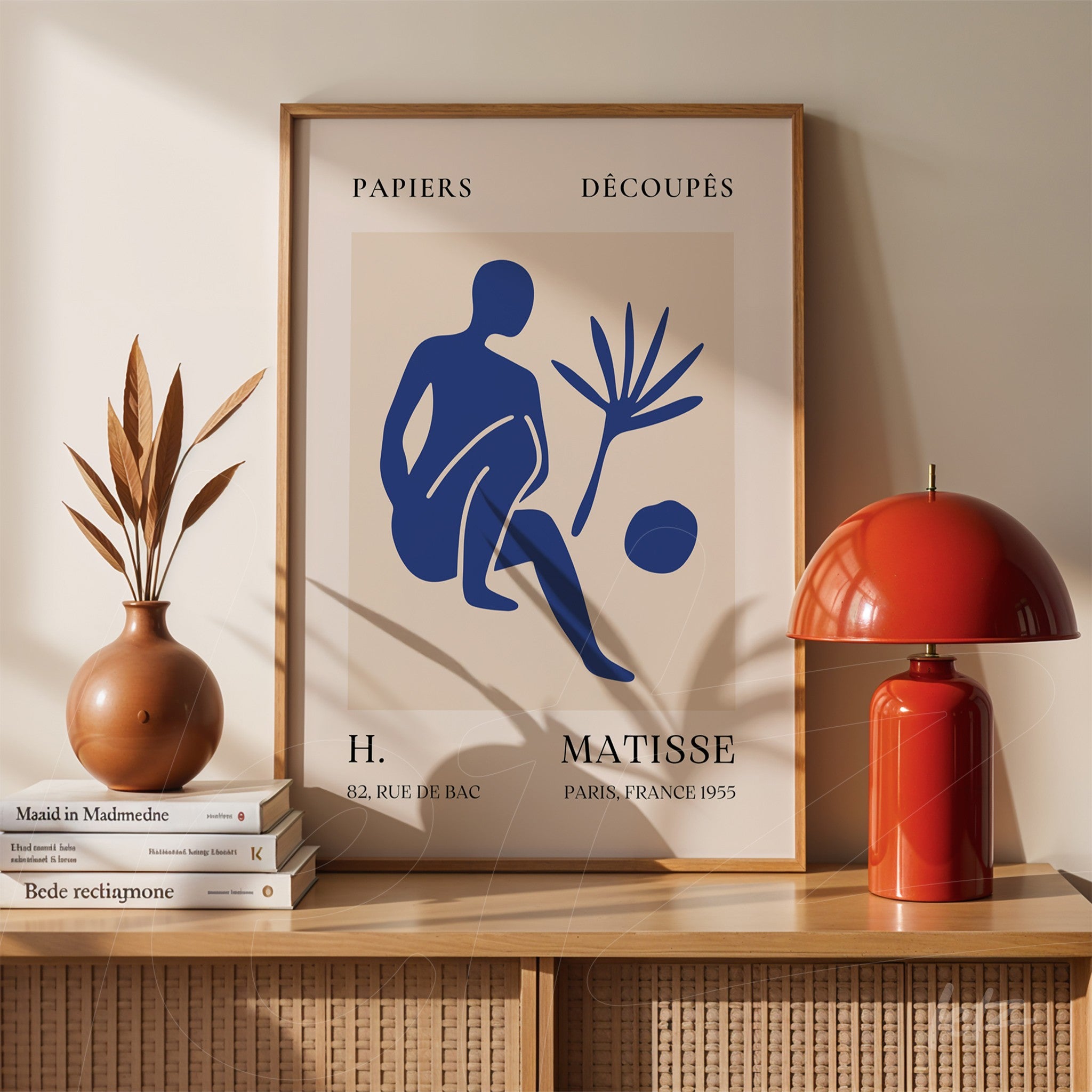 vintage style wall art featuring a blue silhouette of a seated figure and plant, framed in light wood