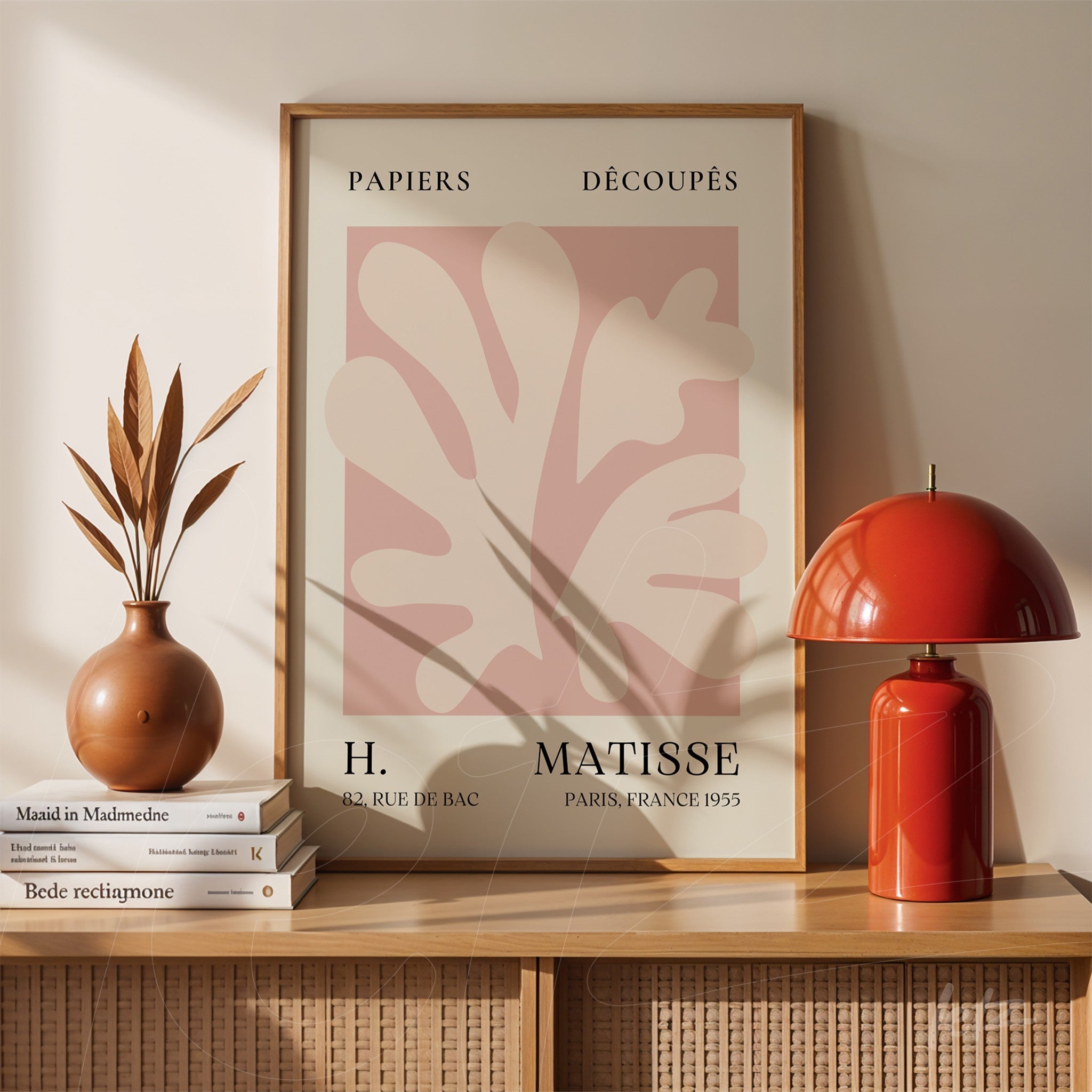 framed modern artwork by Henri Matisse displayed on wooden table with a plant vase