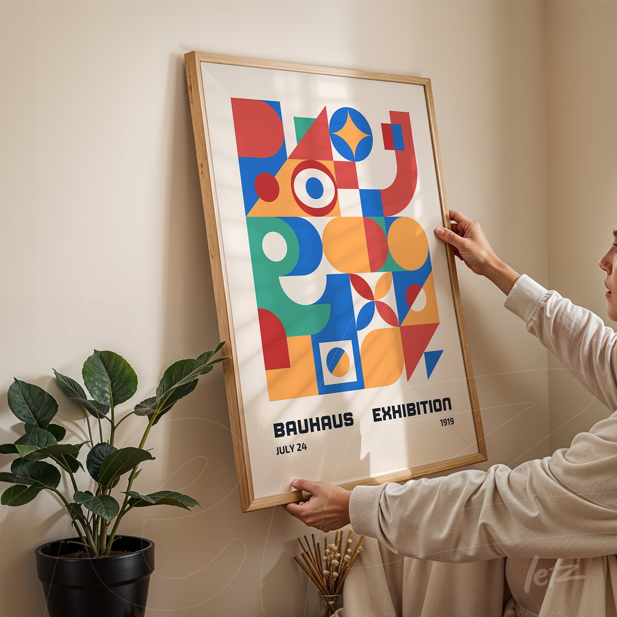 poster featuring colorful abstract bauhaus style art displayed in a natural wooden frame against a cream wall