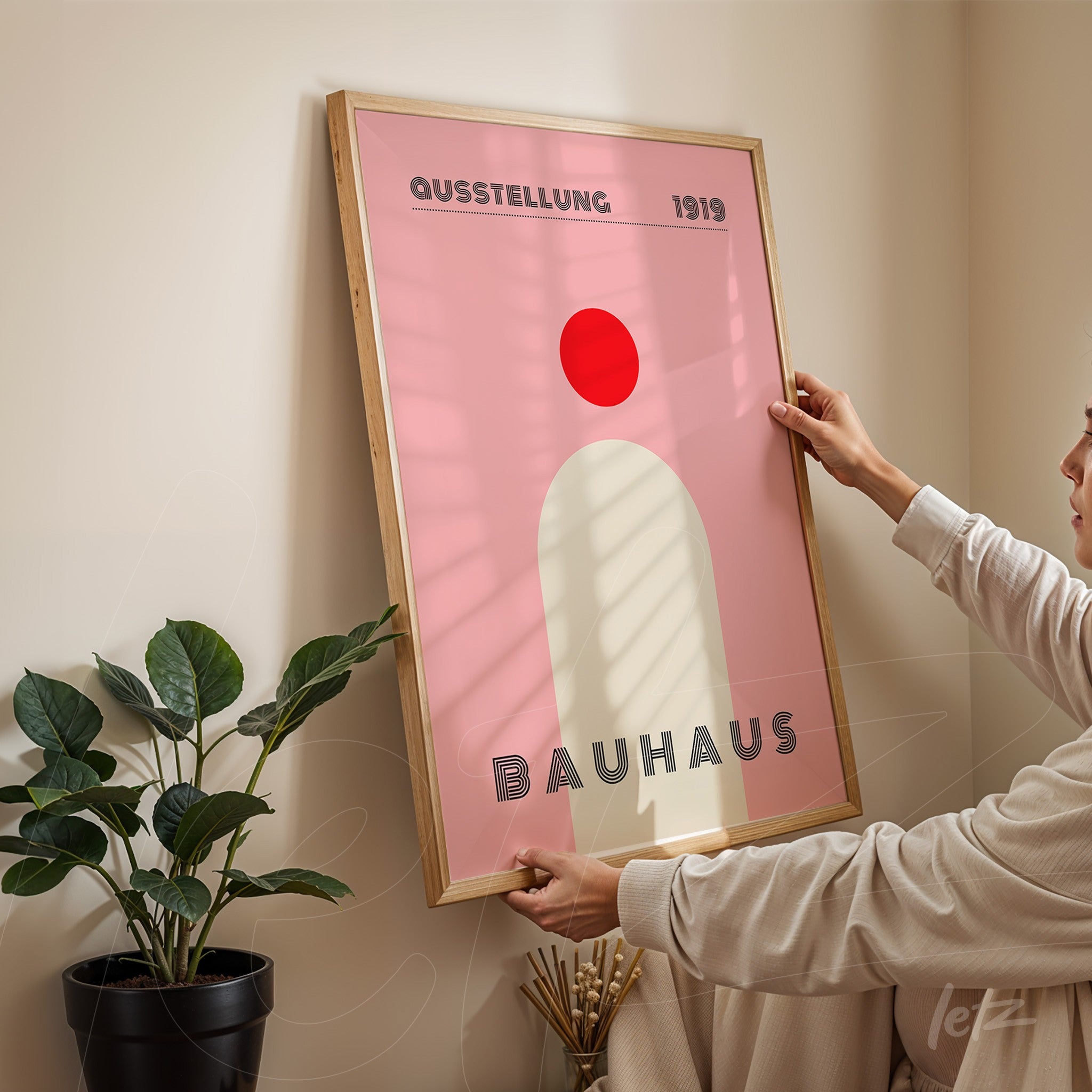 minimalist bauhaus art in pink and red tones with light wood frame