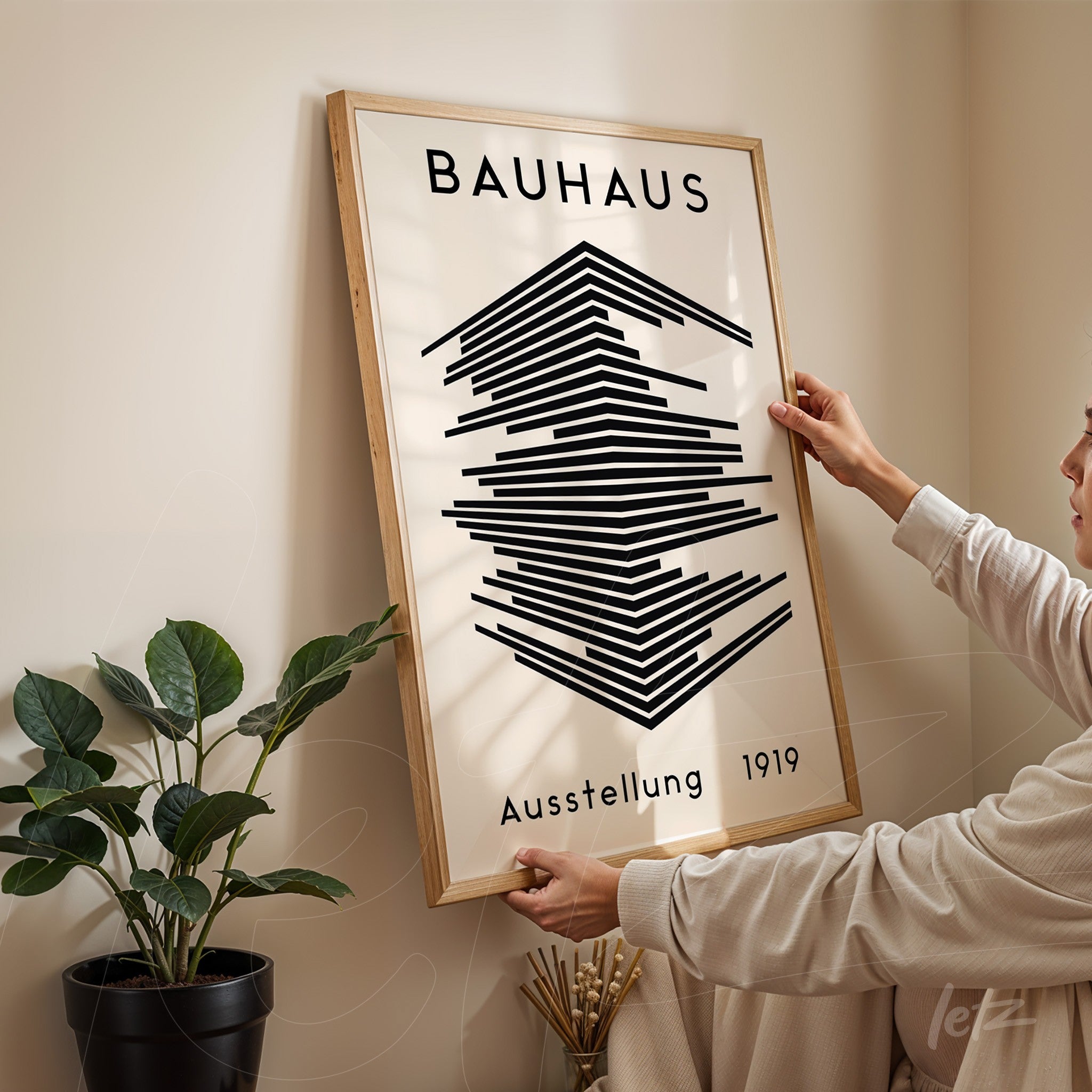 black and white bauhaus poster design in light wooden frame held by a person