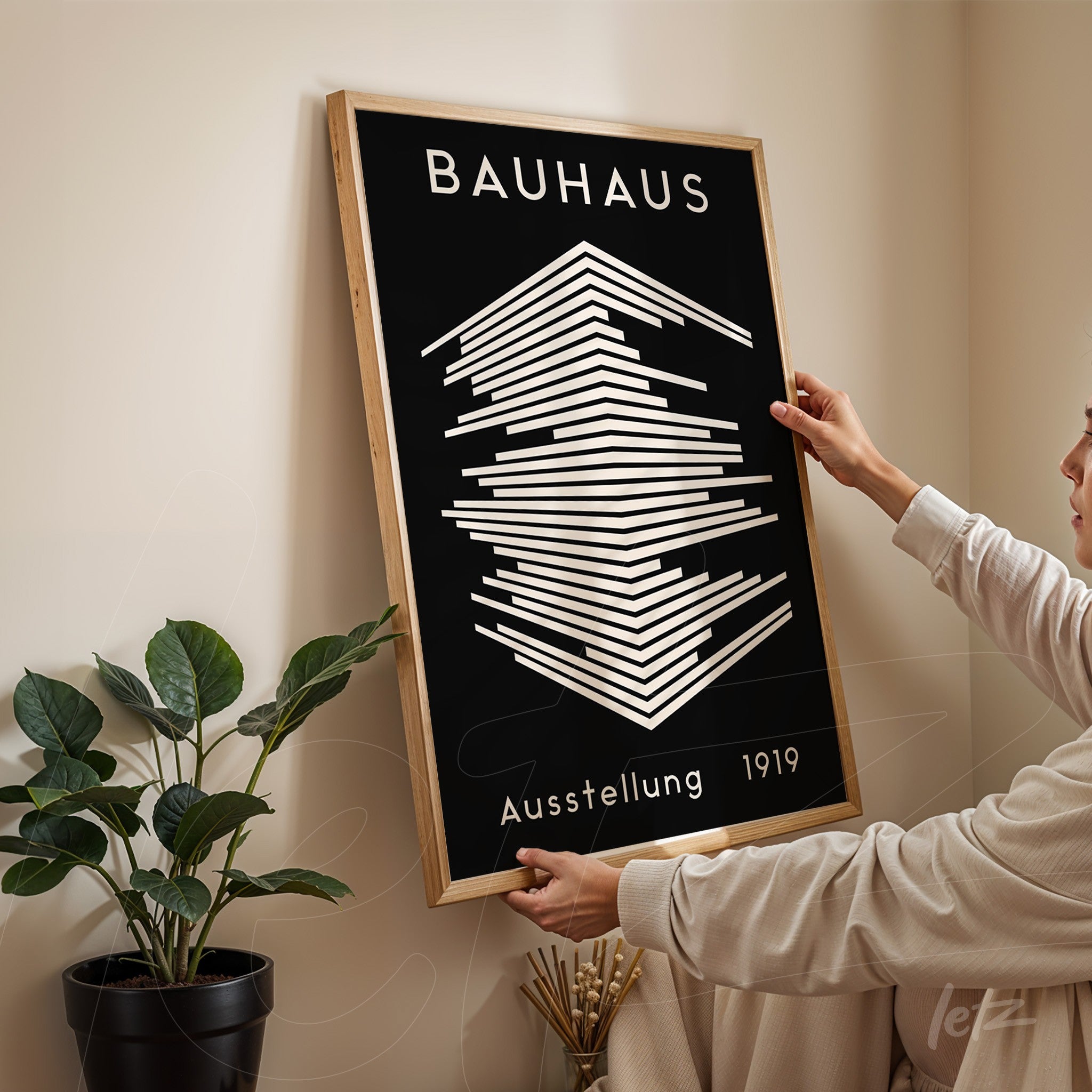 poster featuring a Bauhaus-inspired geometric design with a light wooden frame, displayed on a beige wall