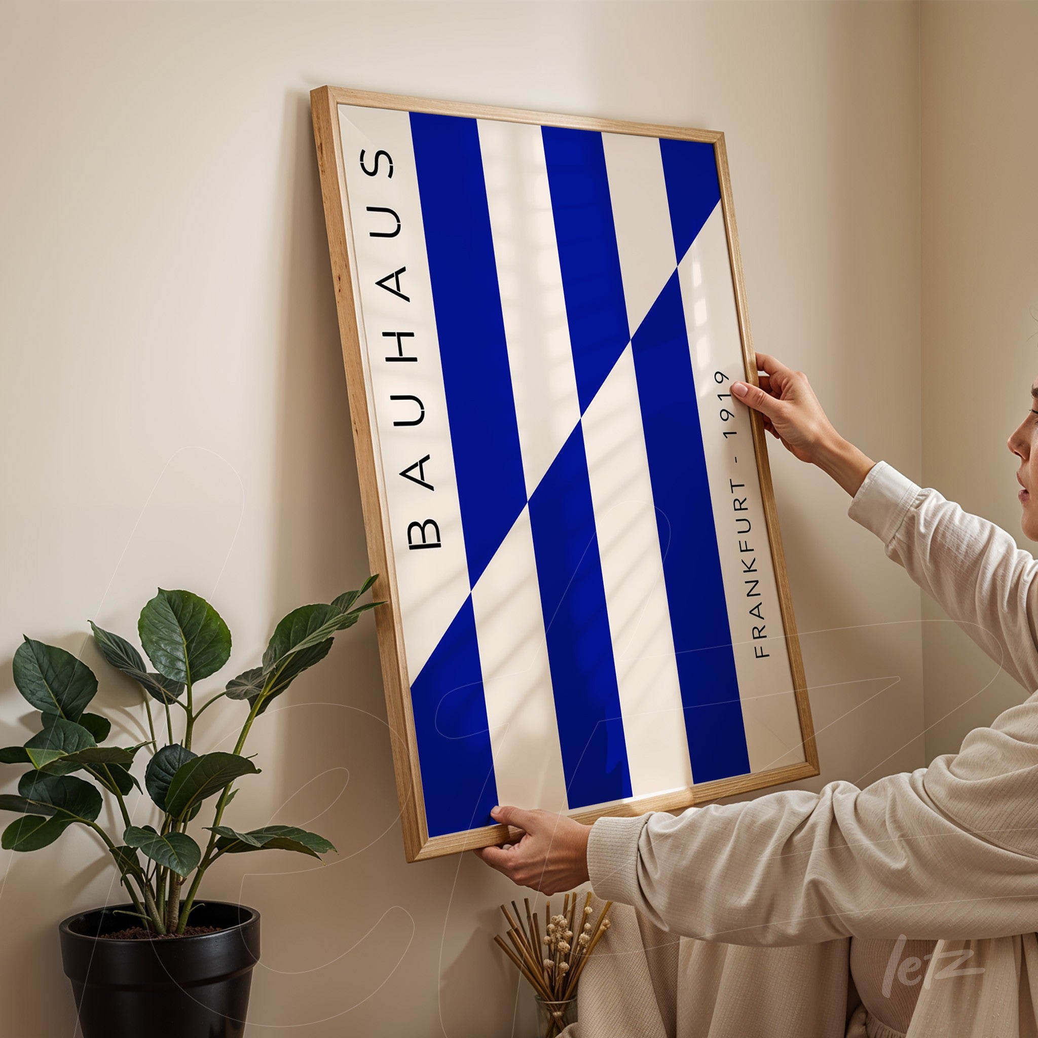 framed art piece with blue and white geometric design inspired by bauhaus, held against a corner wall