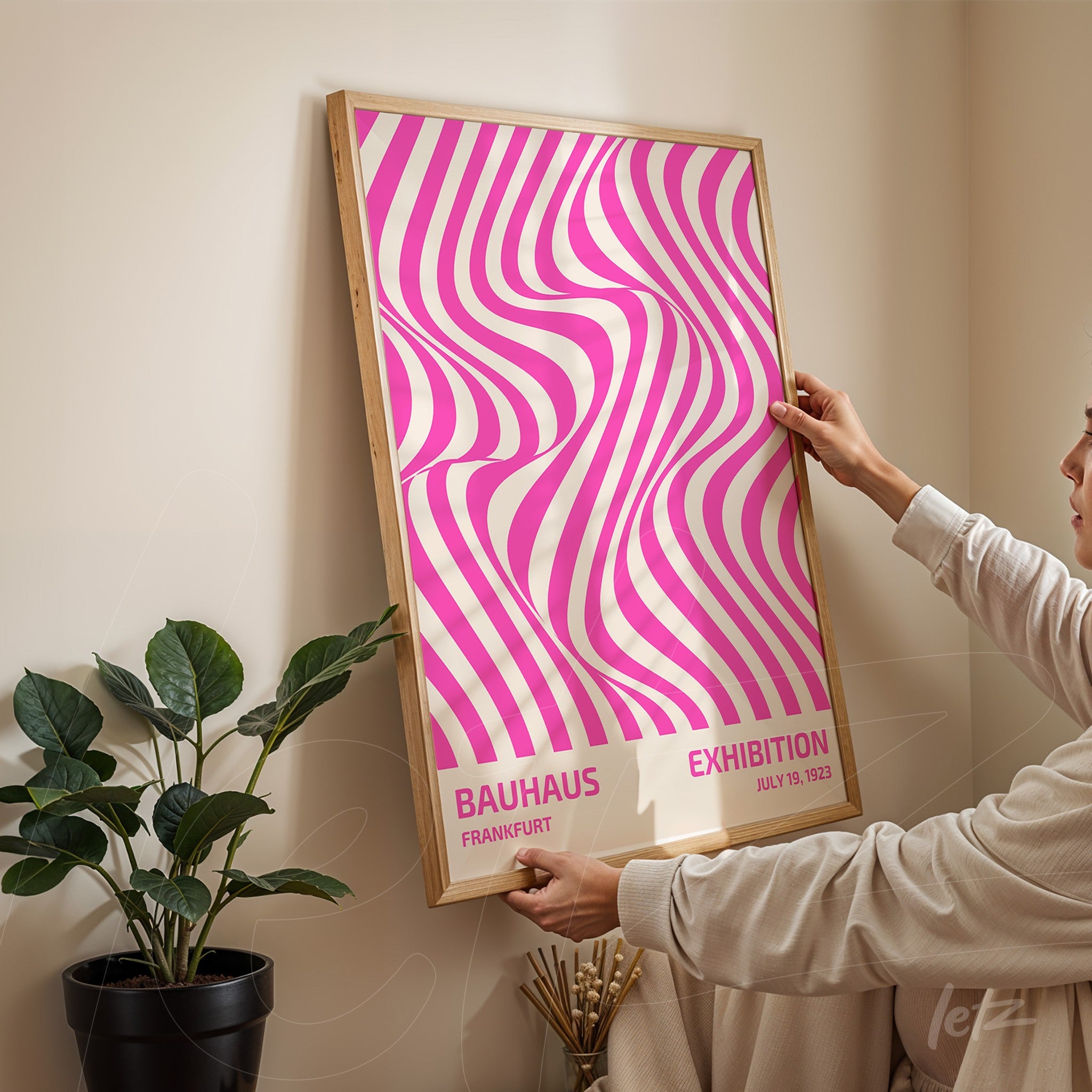 poster featuring abstract pink and white design with text on bauhaus exhibition in light wood frame