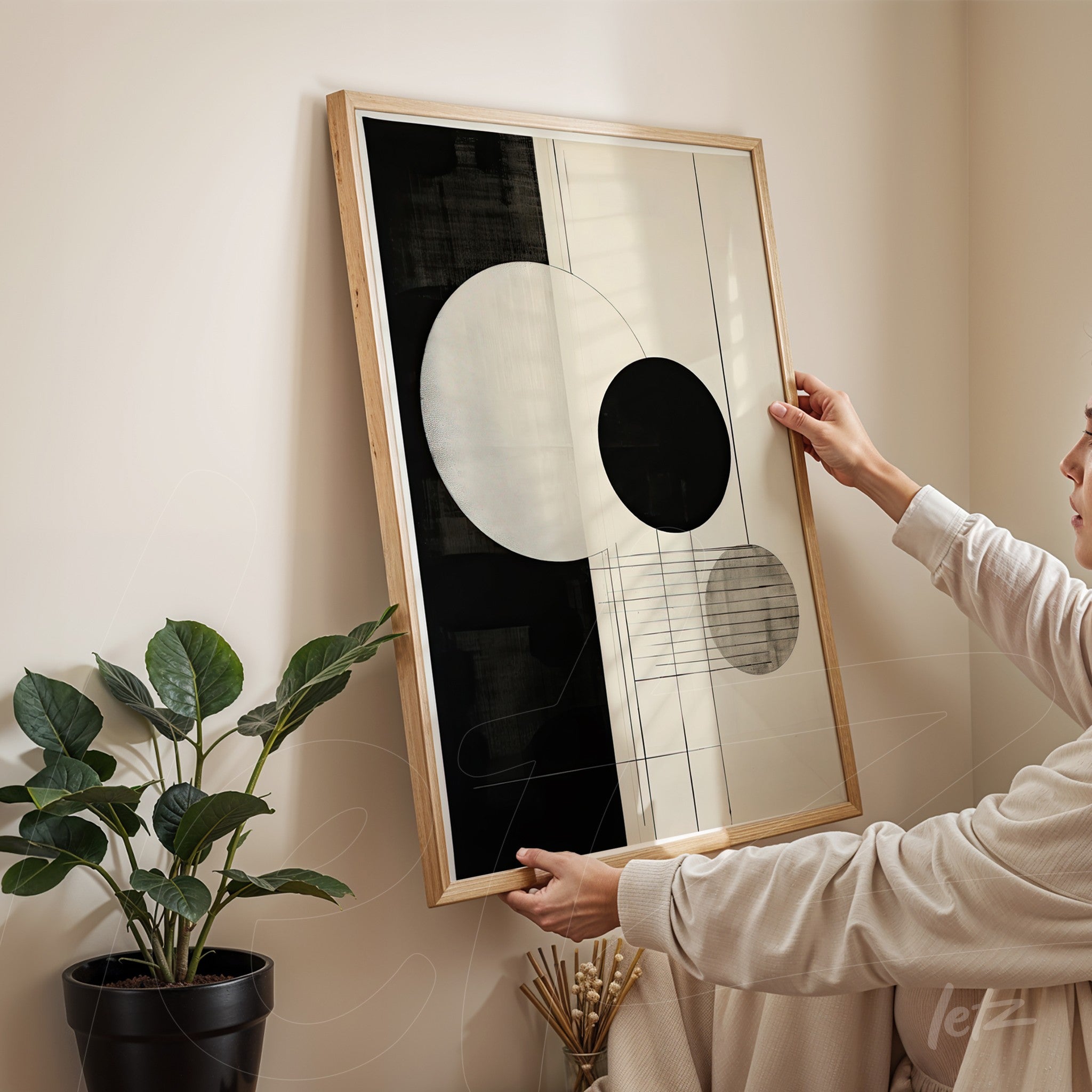 abstract wall art featuring circular shapes in black and white with light wood frame