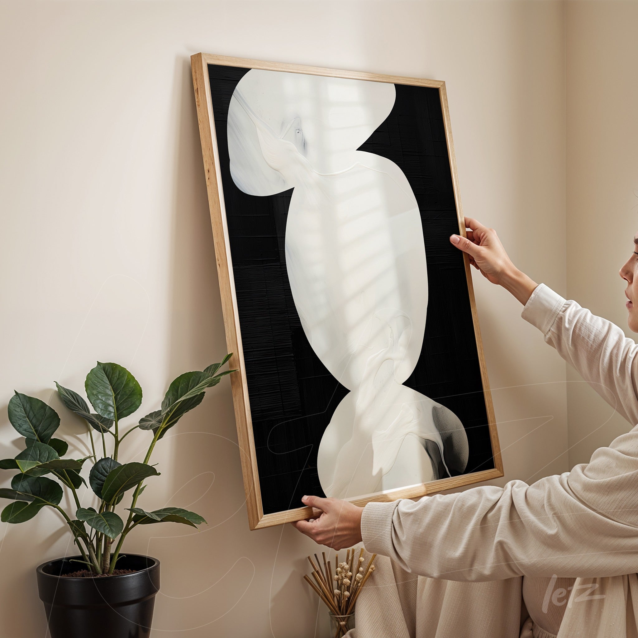 framed abstract art in white and black tones presented in a cozy setting