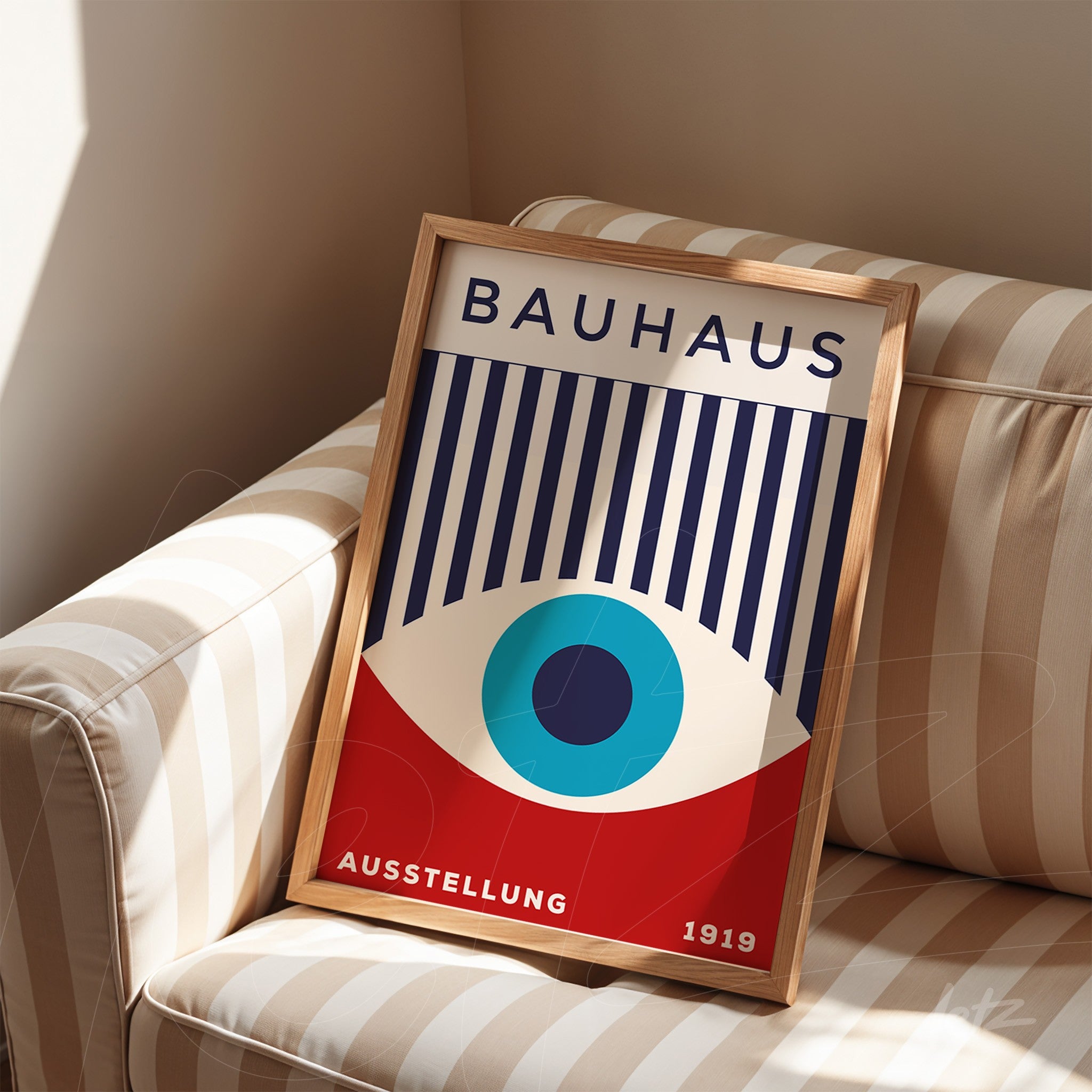 bauhaus style poster with stylized eye and text in wooden frame on striped sofa