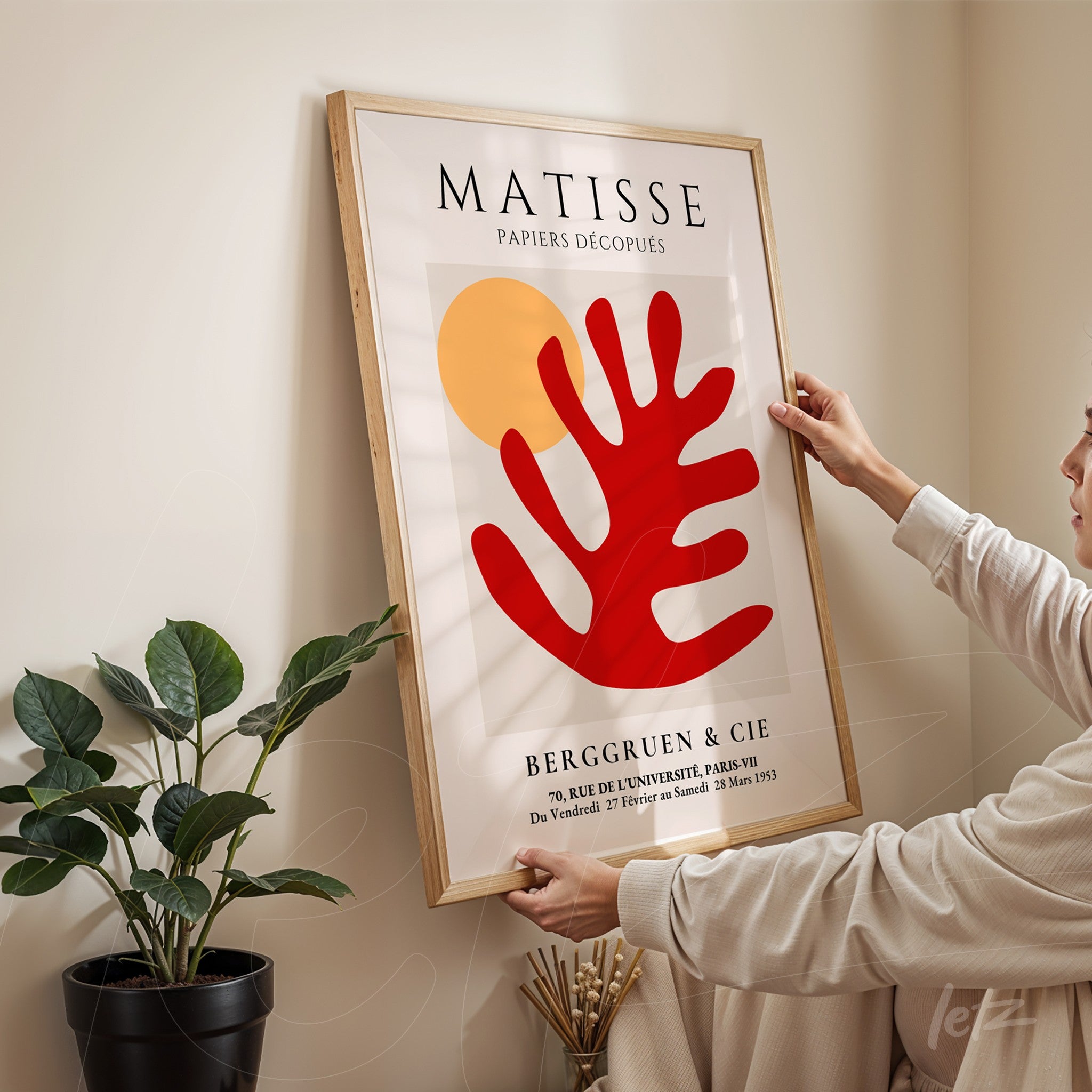 decorative wall art featuring abstract design in red and yellow, framed in light wood, displayed against a neutral wall