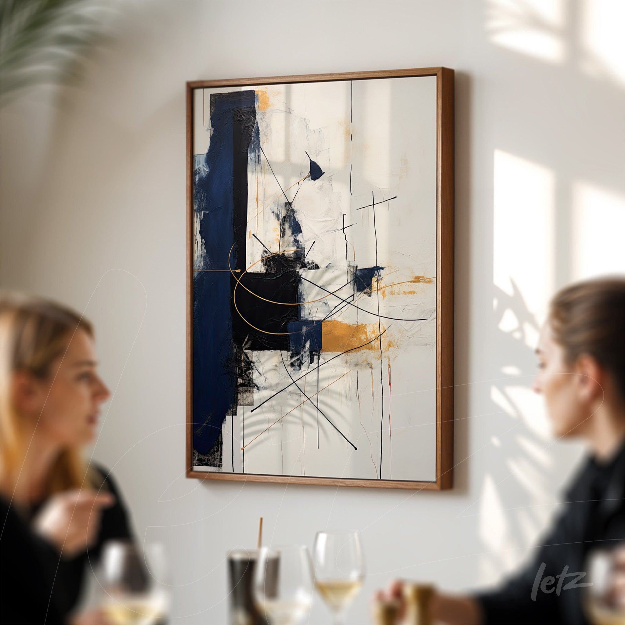 abstract artwork featuring geometric shapes in shades of blue, black, and gold, framed in light wood displayed on a light wall