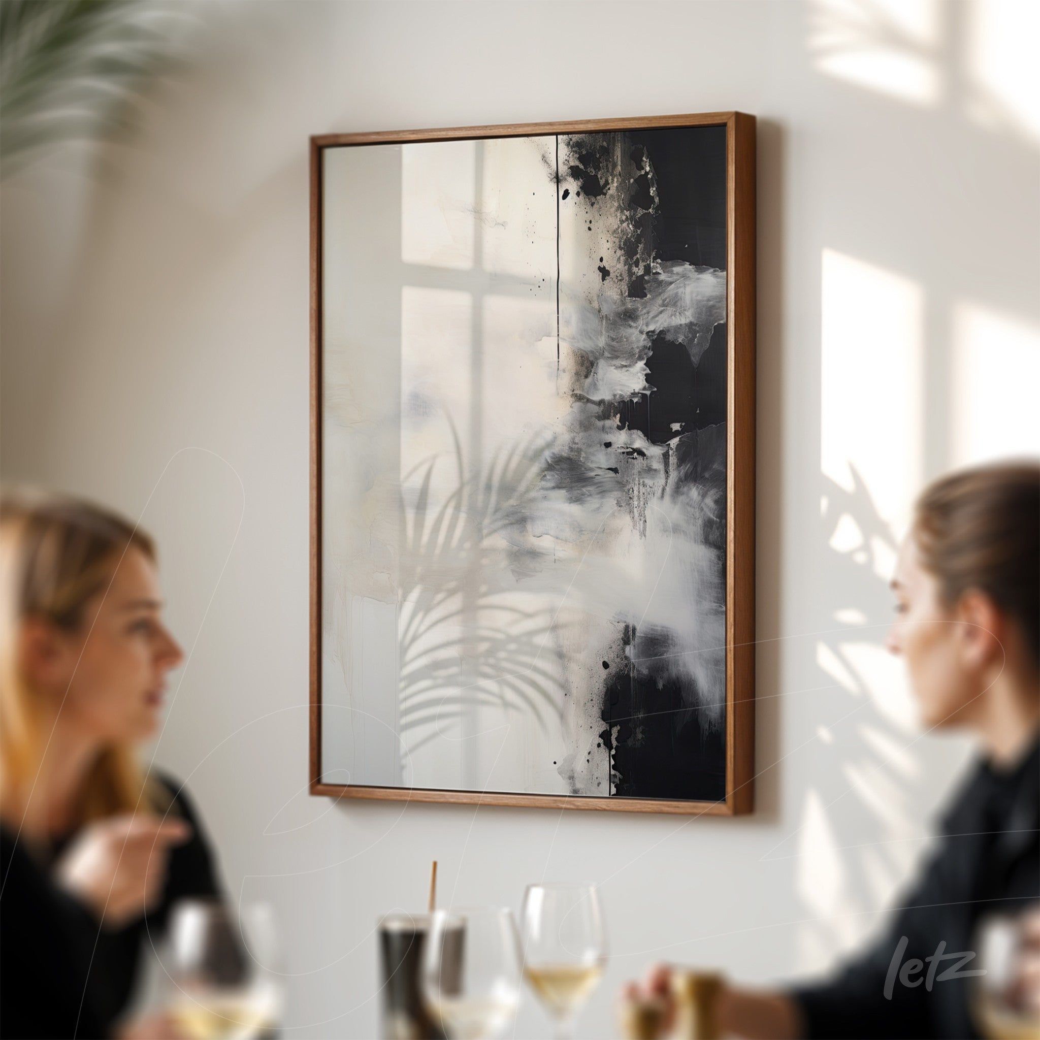 abstract wall art in black and white with wooden frame displayed on a light wall