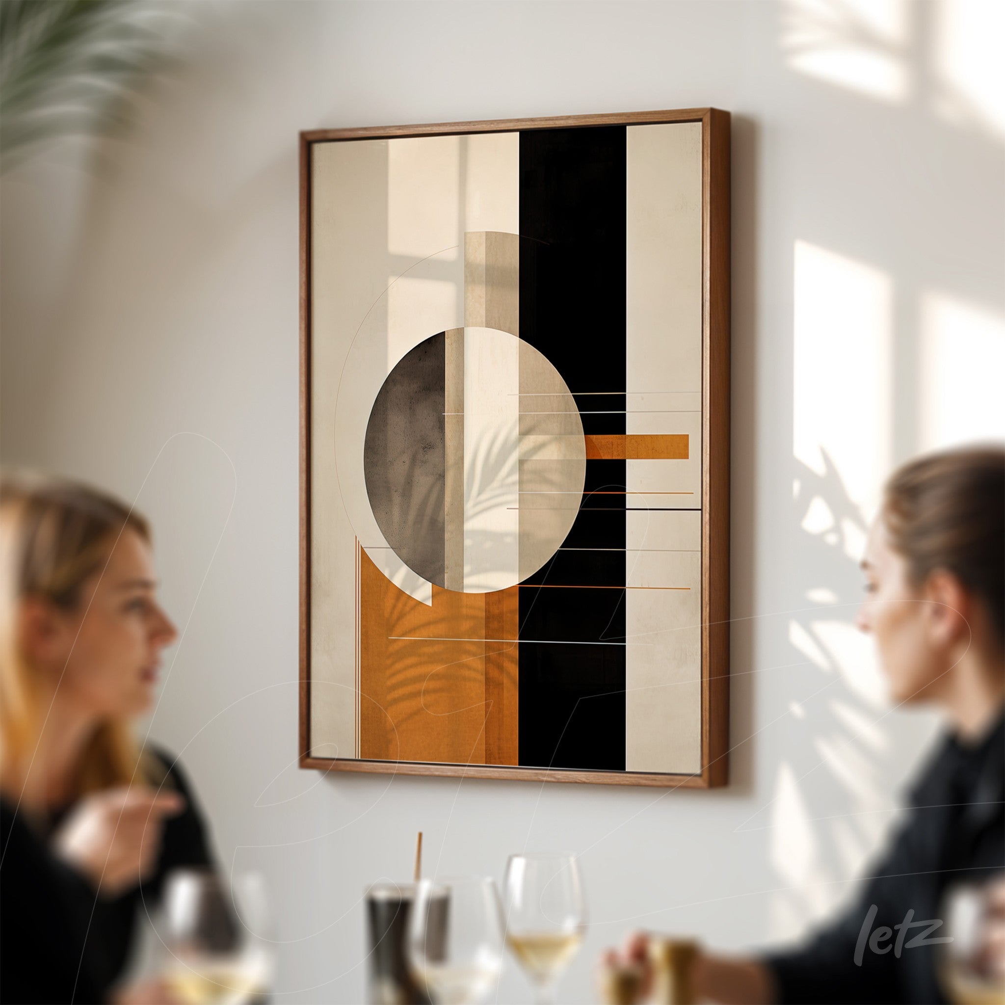 modern wall art in dark wood frame featuring geometric shapes in shades of orange, black and beige, displayed against a light wall with natural lighting