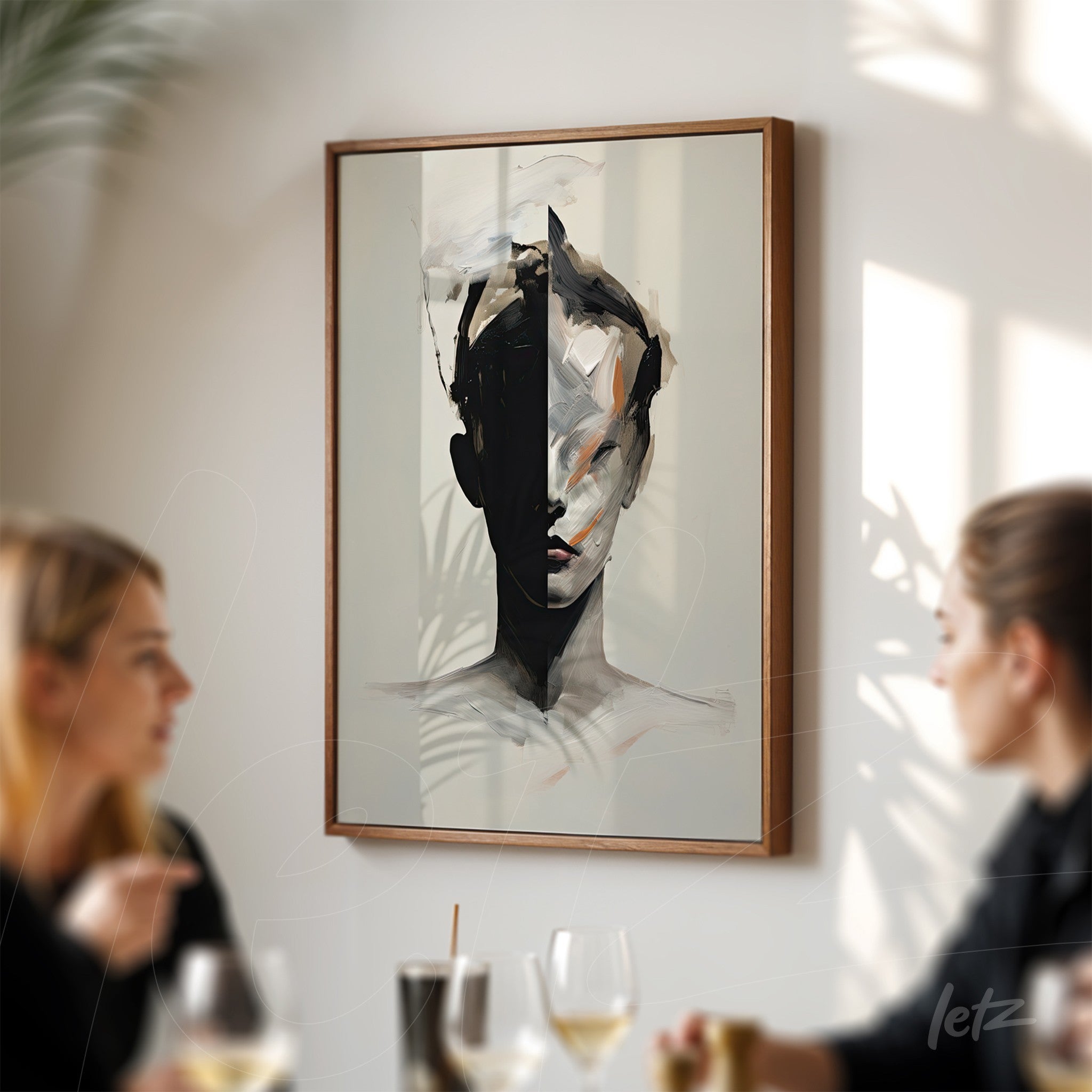 abstract artwork depicting a face in black and white tones, framed in dark wood against a light wall