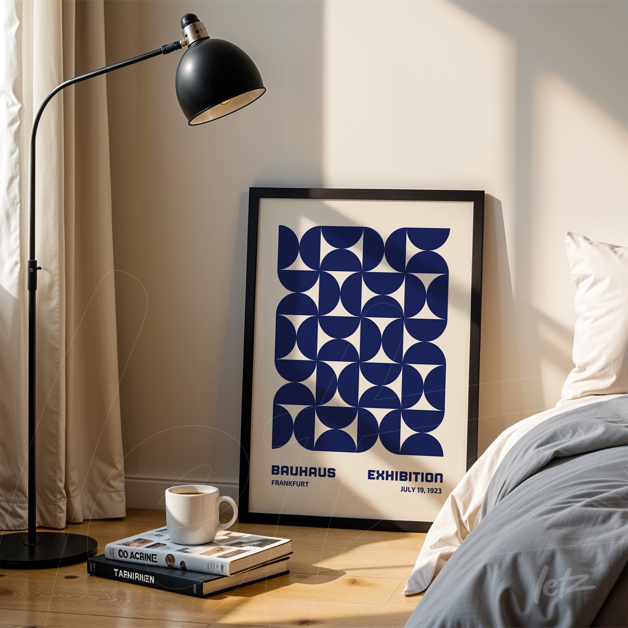 framed geometric blue art piece resting against a light wall next to a bed, featuring a black floor lamp nearby