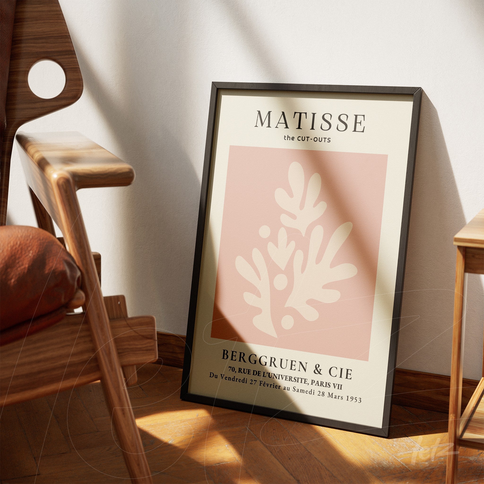 framed art inspired by matisse featuring abstract shapes on soft pink background with vintage typography leaning next to a wooden chair