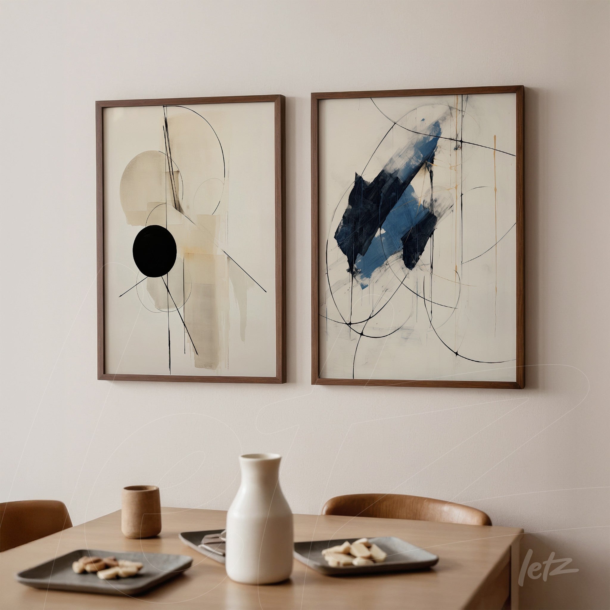 composition of two framed abstract artworks in brown frames on light wall, one featuring geometric shapes and a black circle, the other with blue smudges and fine lines