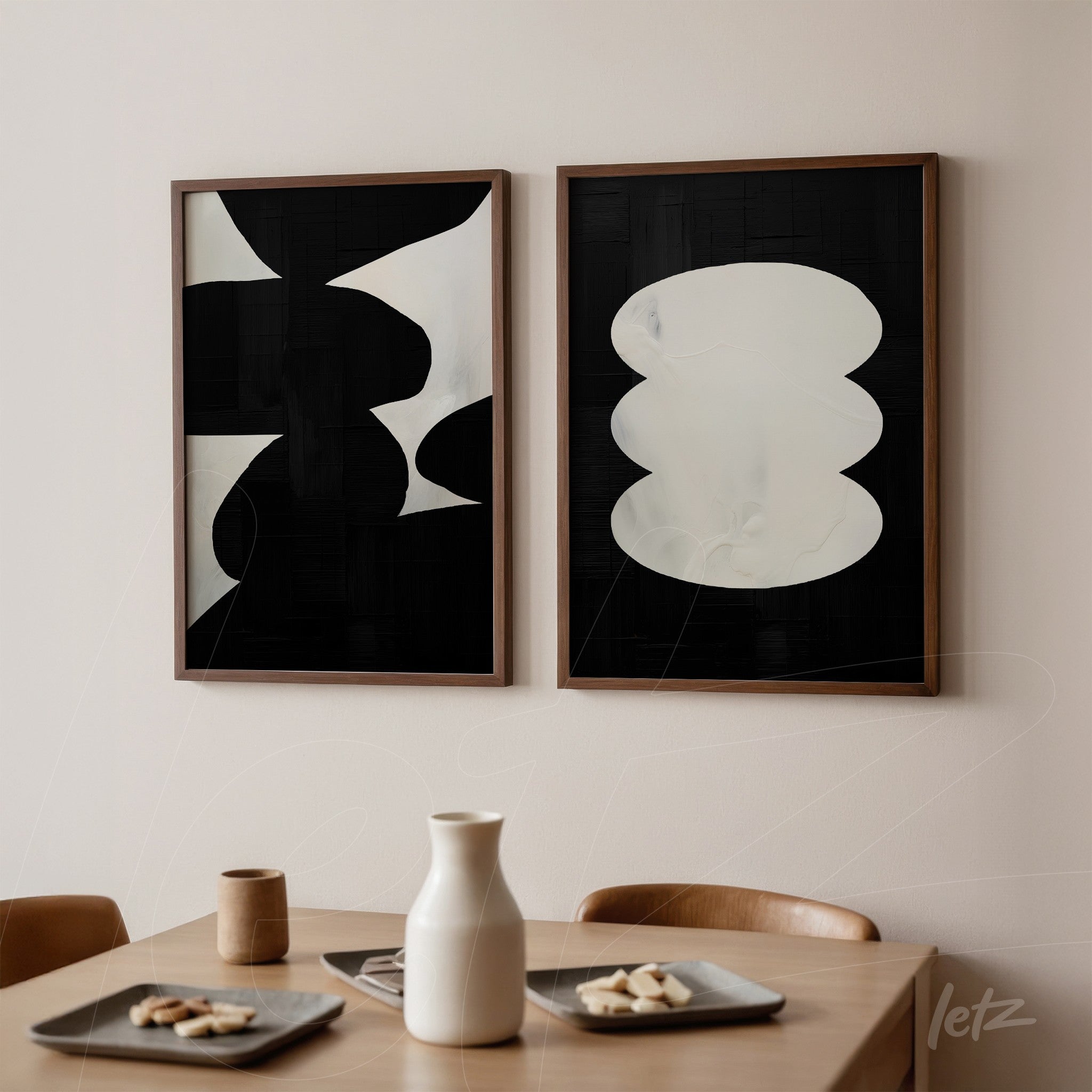 composition of abstract wall art in black and white with wooden frames displayed on a light wall