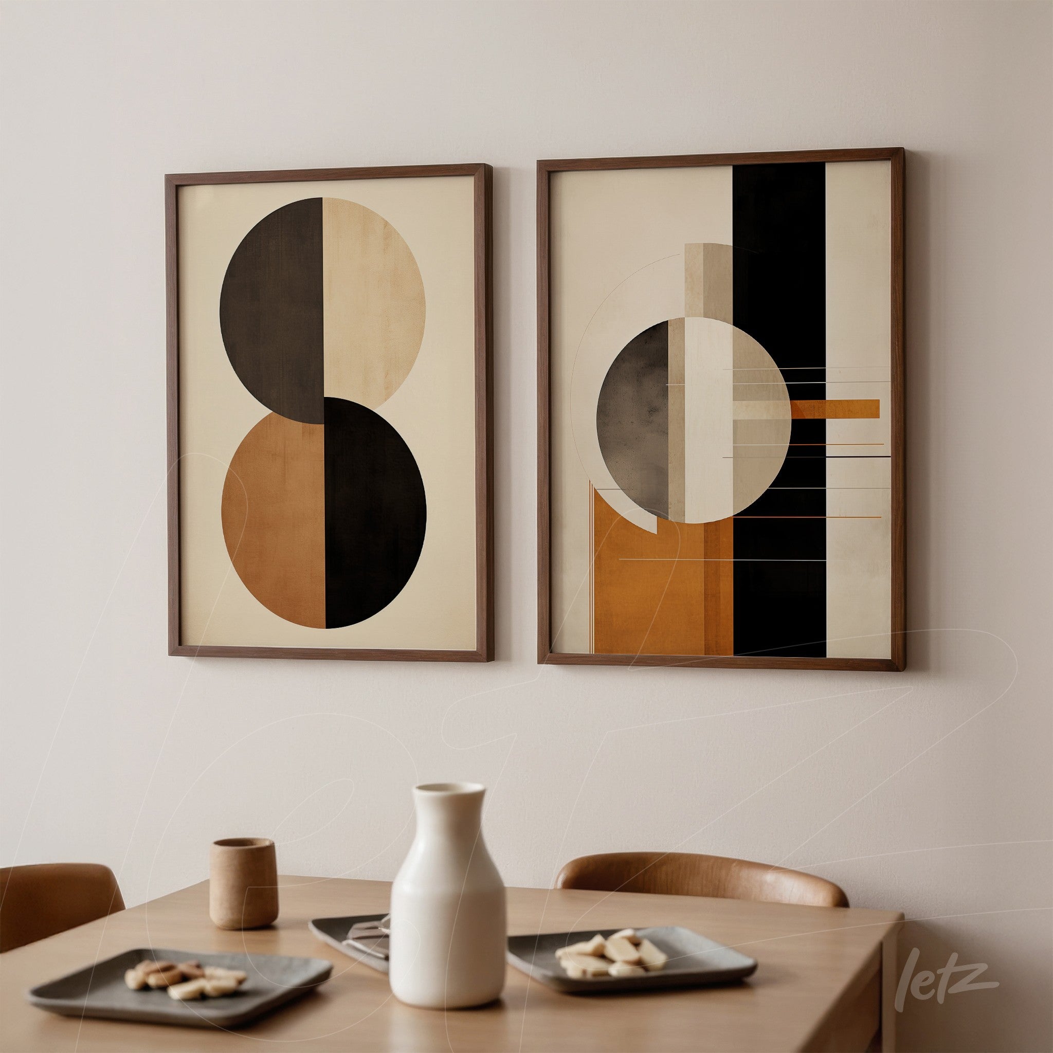 composition of two framed abstract artworks with light wood frames, featuring earthy tones on one and geometric shapes in black and orange on the other, displayed against a neutral wall