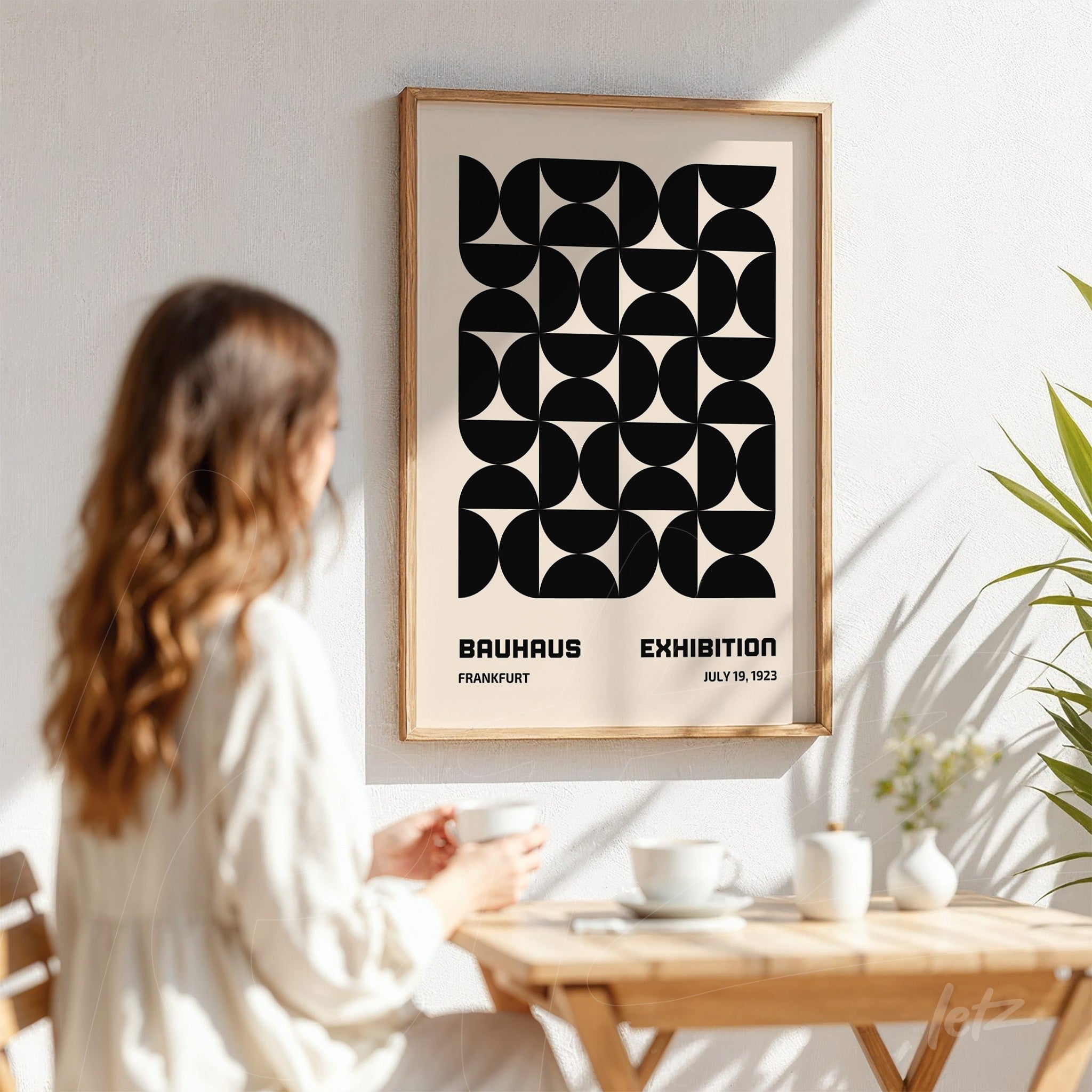 1923 bauhaus exhibition poster with light wood frame displayed on a white wall