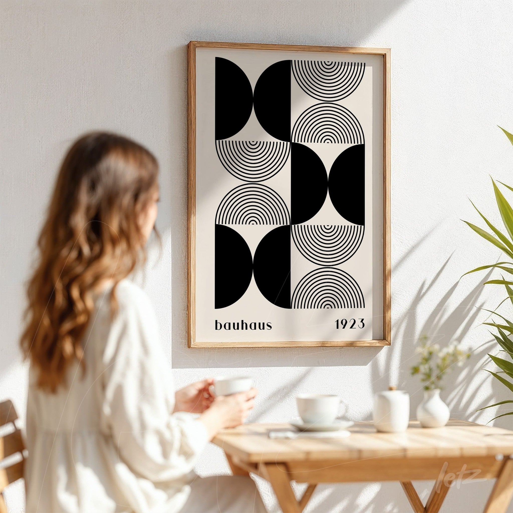 geometric bauhaus style art in a light wood frame displayed on white wall