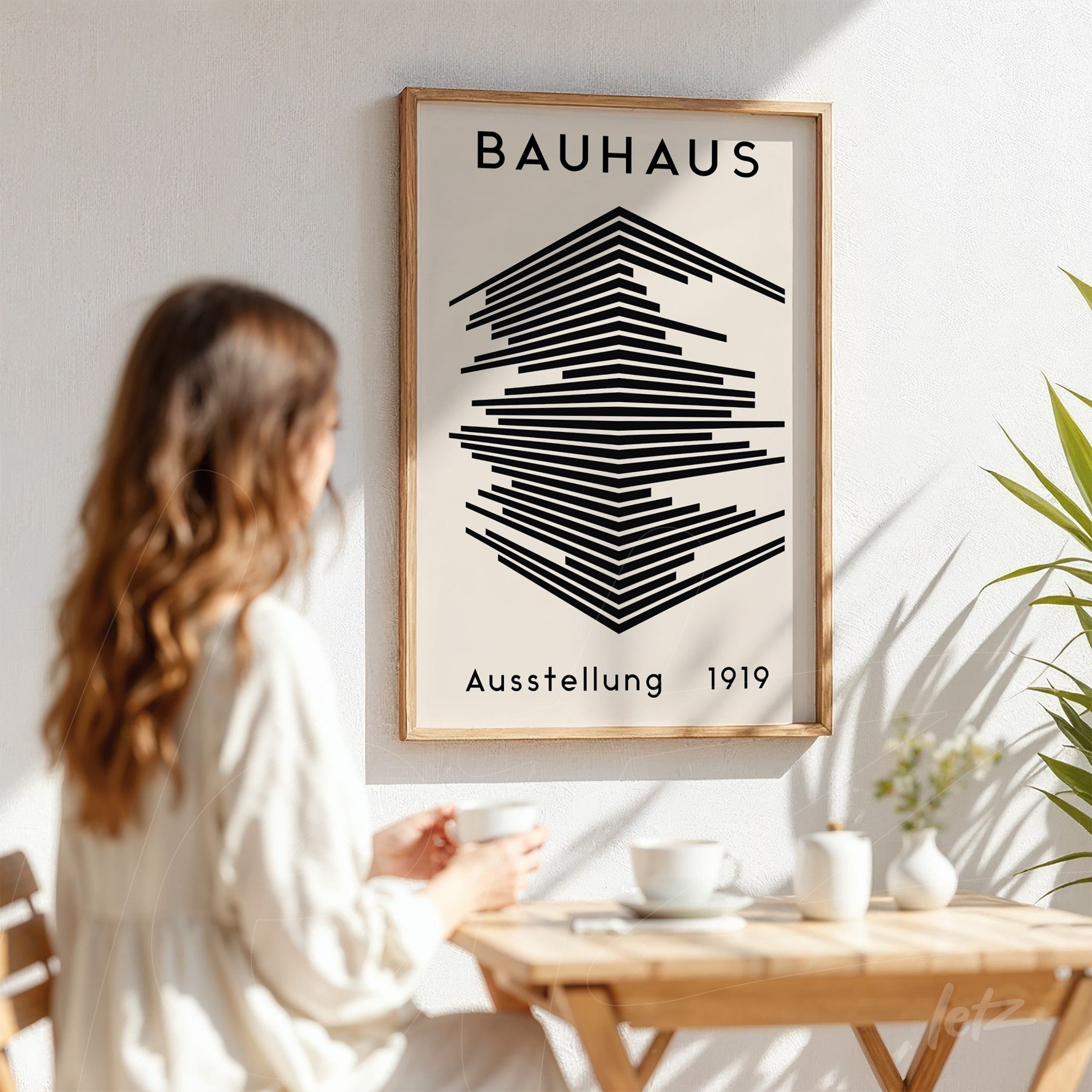 bauhaus style poster in light wood frame on white wall