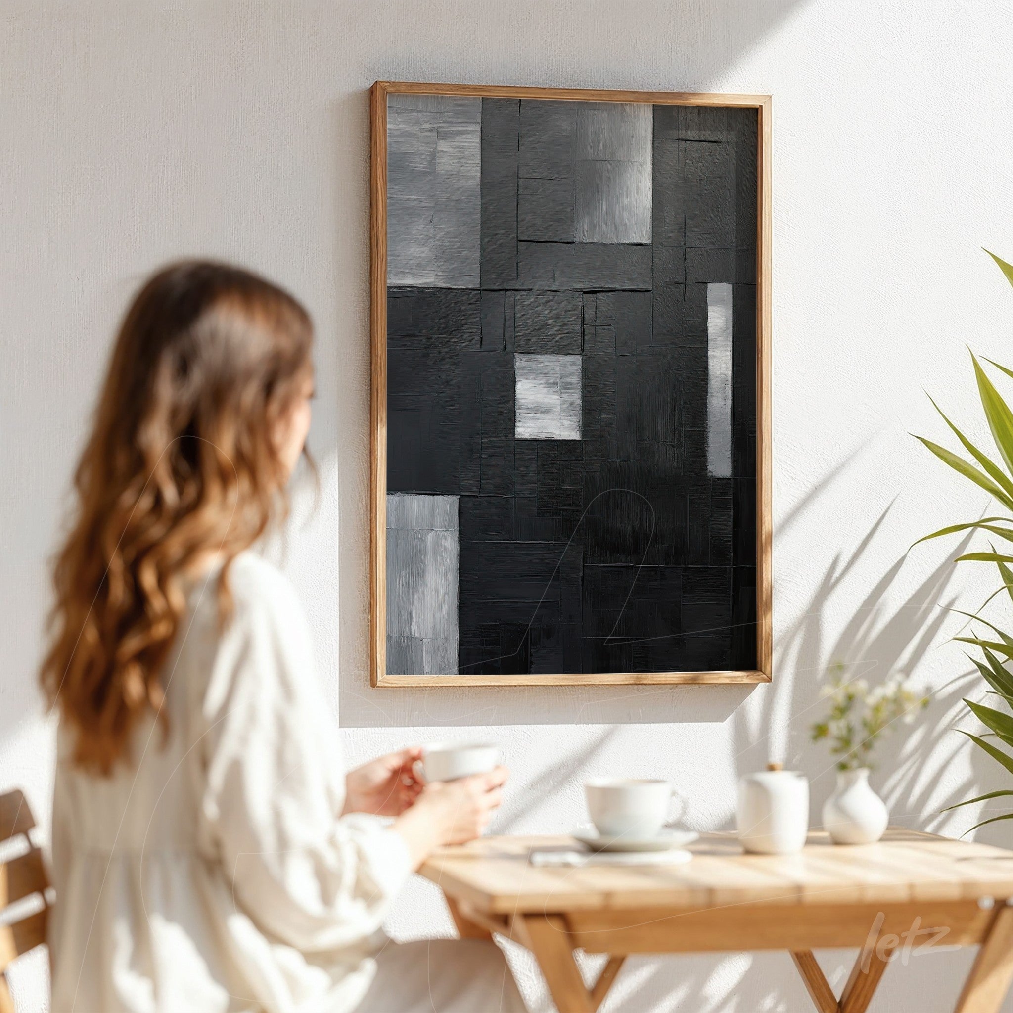 abstract wall art in shades of black and gray with light wooden frame displayed on white wall