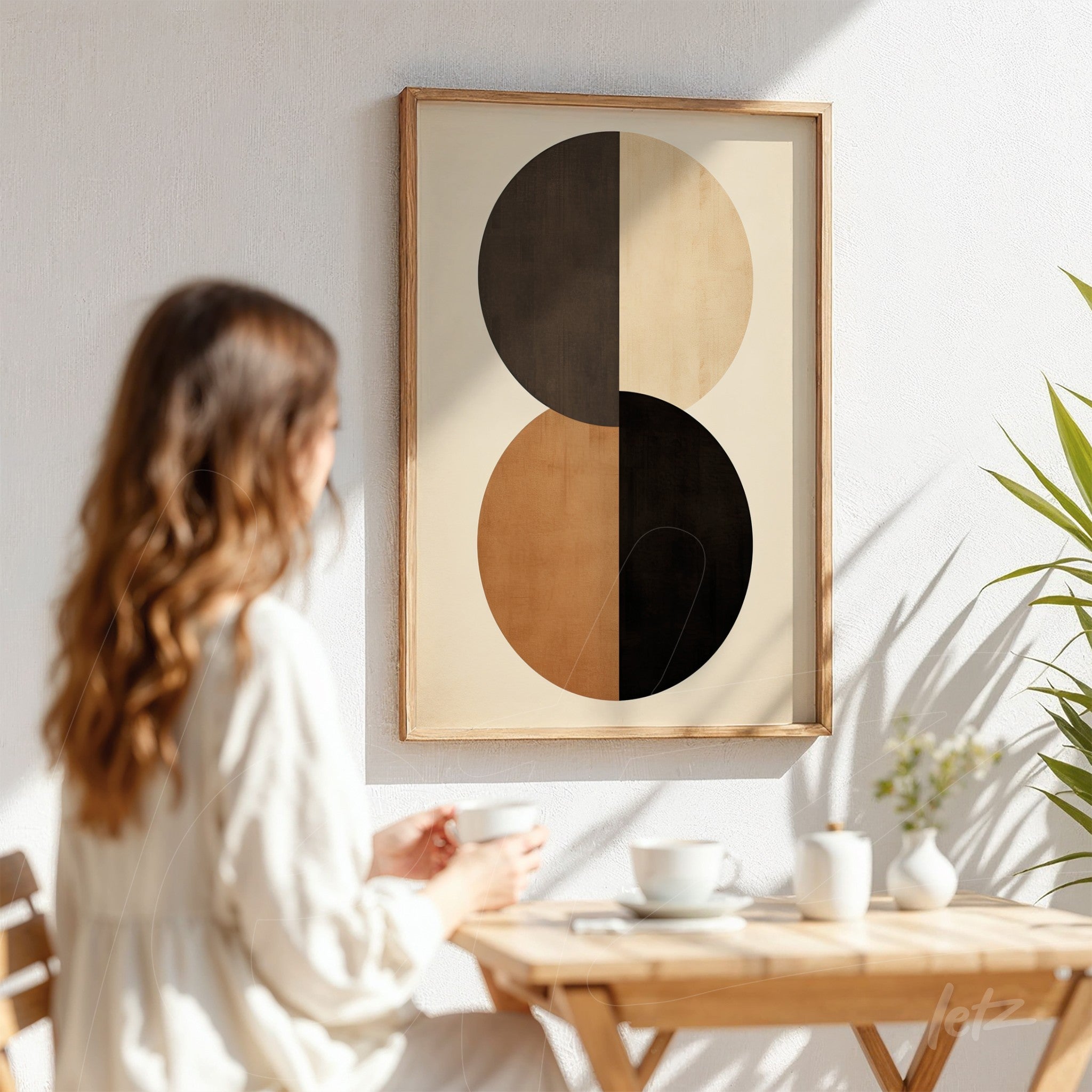 framed wall art featuring modern design with two circular shapes, one in black and the other in gold, set against a white wall