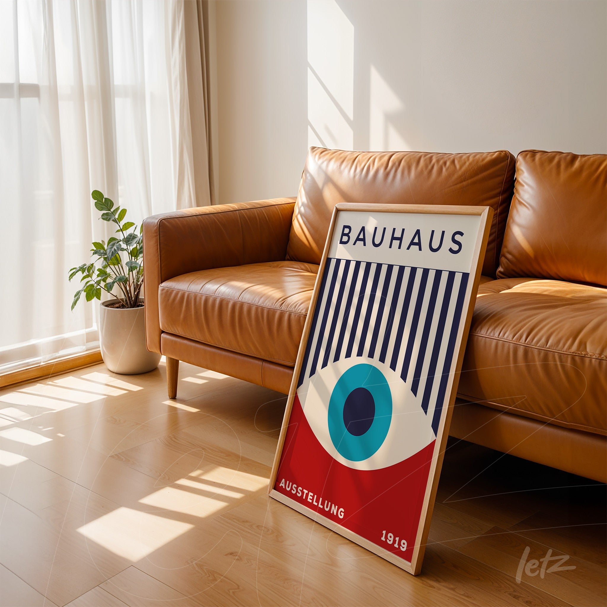 poster print featuring Bauhaus geometric design displayed in light wood frame leaning against a leather sofa