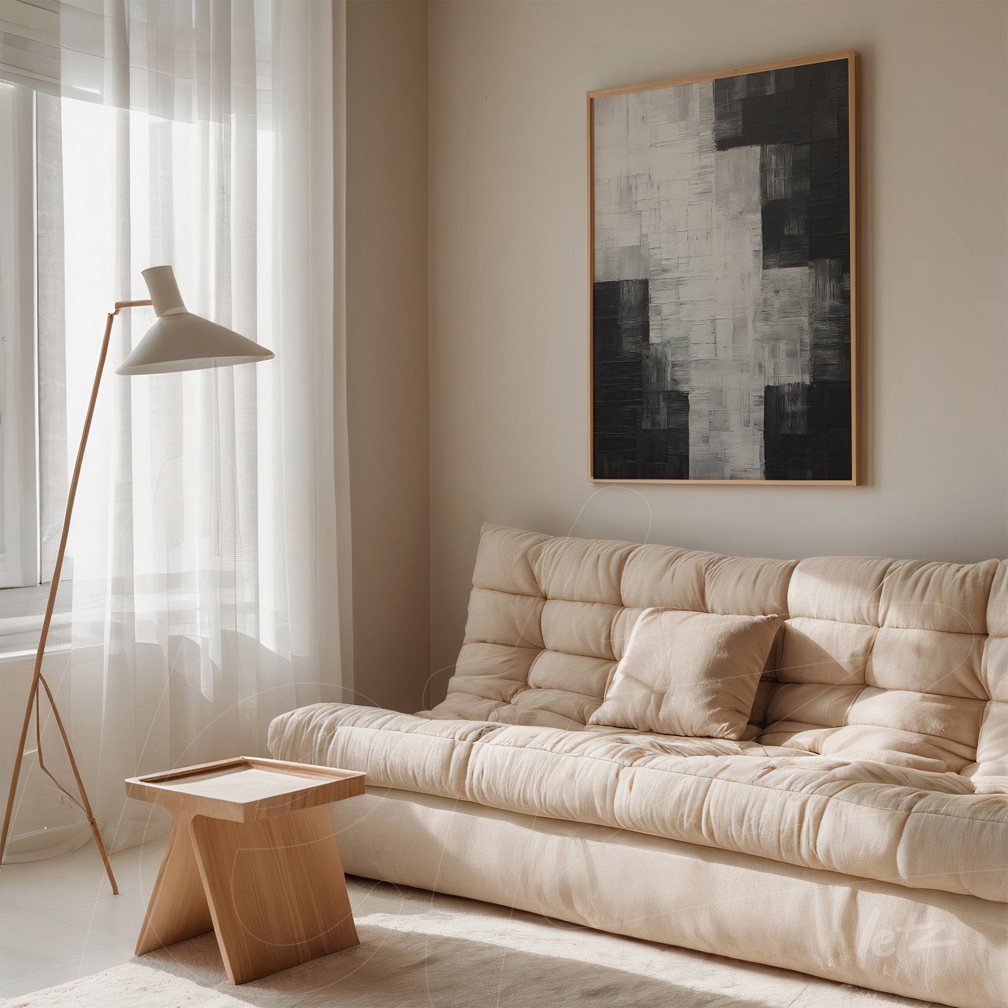 abstract artwork in shades of gray and black with light wood frame showcased in a minimalist setting featuring a beige fabric sofa