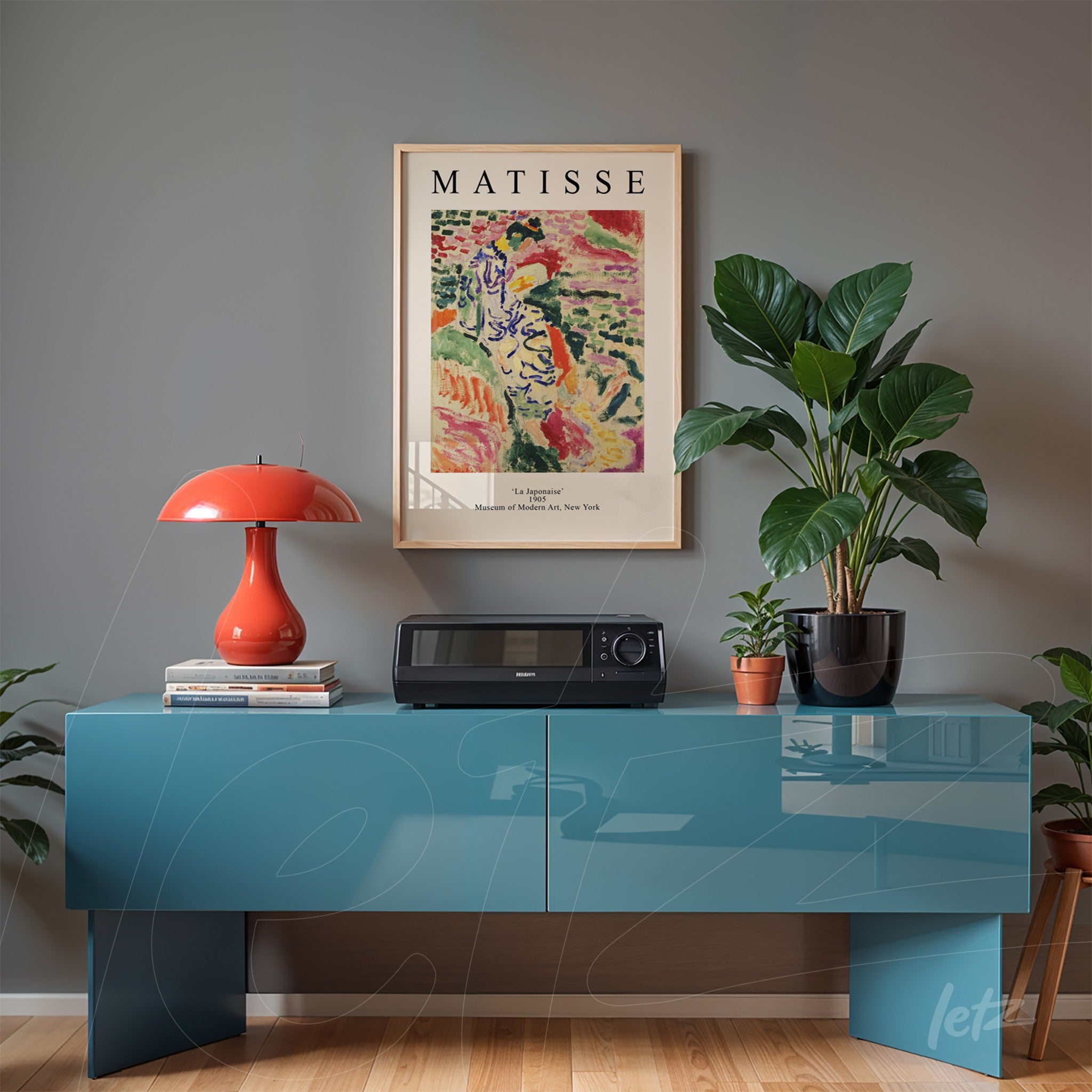framed wall art of Matisse set on gray wall above a blue side table with modern decor items