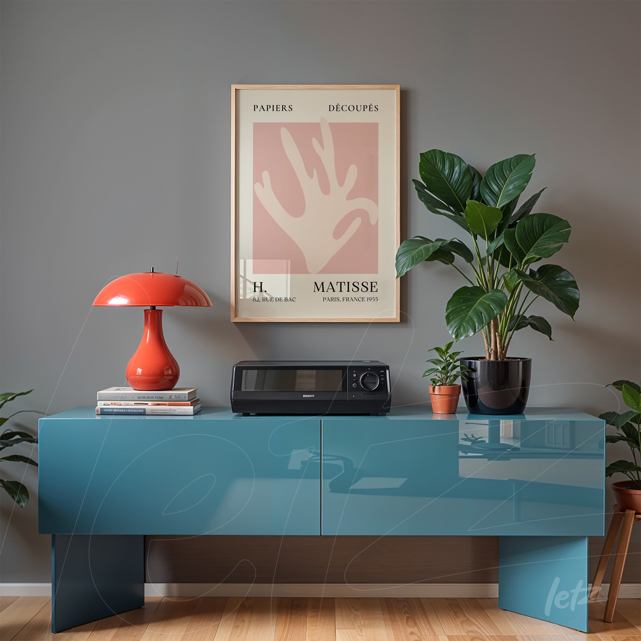framed art of Matisse displayed on a modern blue sideboard next to a red lamp and potted plants