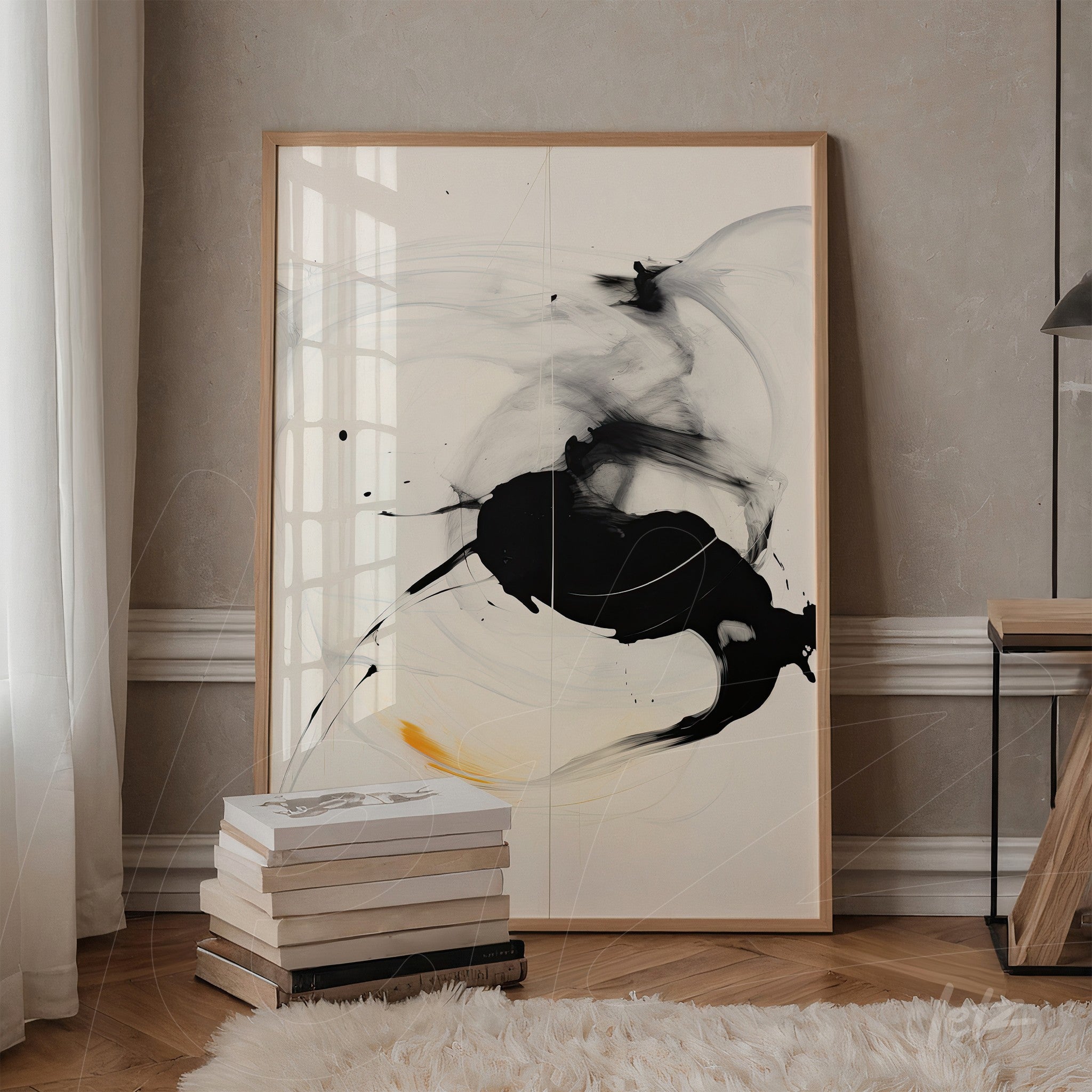abstract wall art in light frame featuring black, gray strokes and a hint of yellow on a light background displayed in a stylish setting