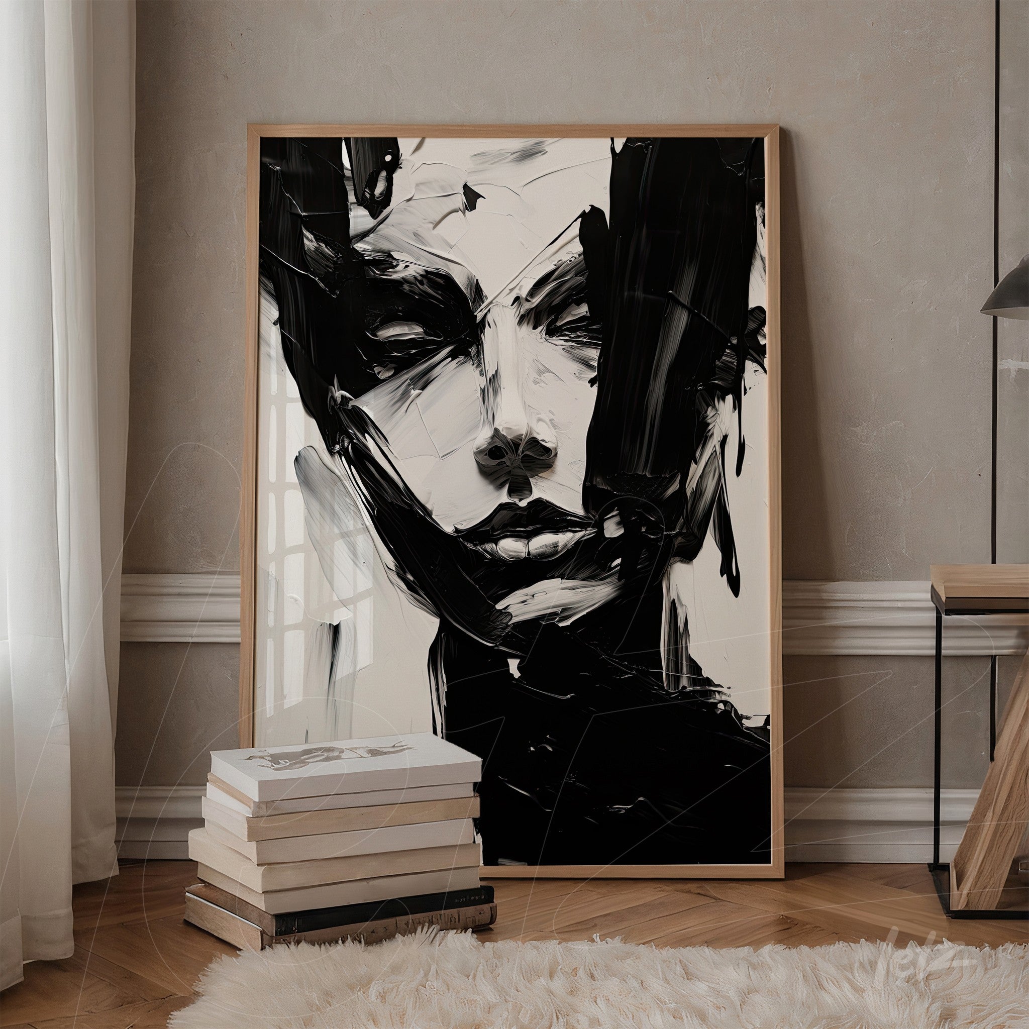 abstract wall art of a female face in a light frame displayed in a cozy setting with stacked books beside it