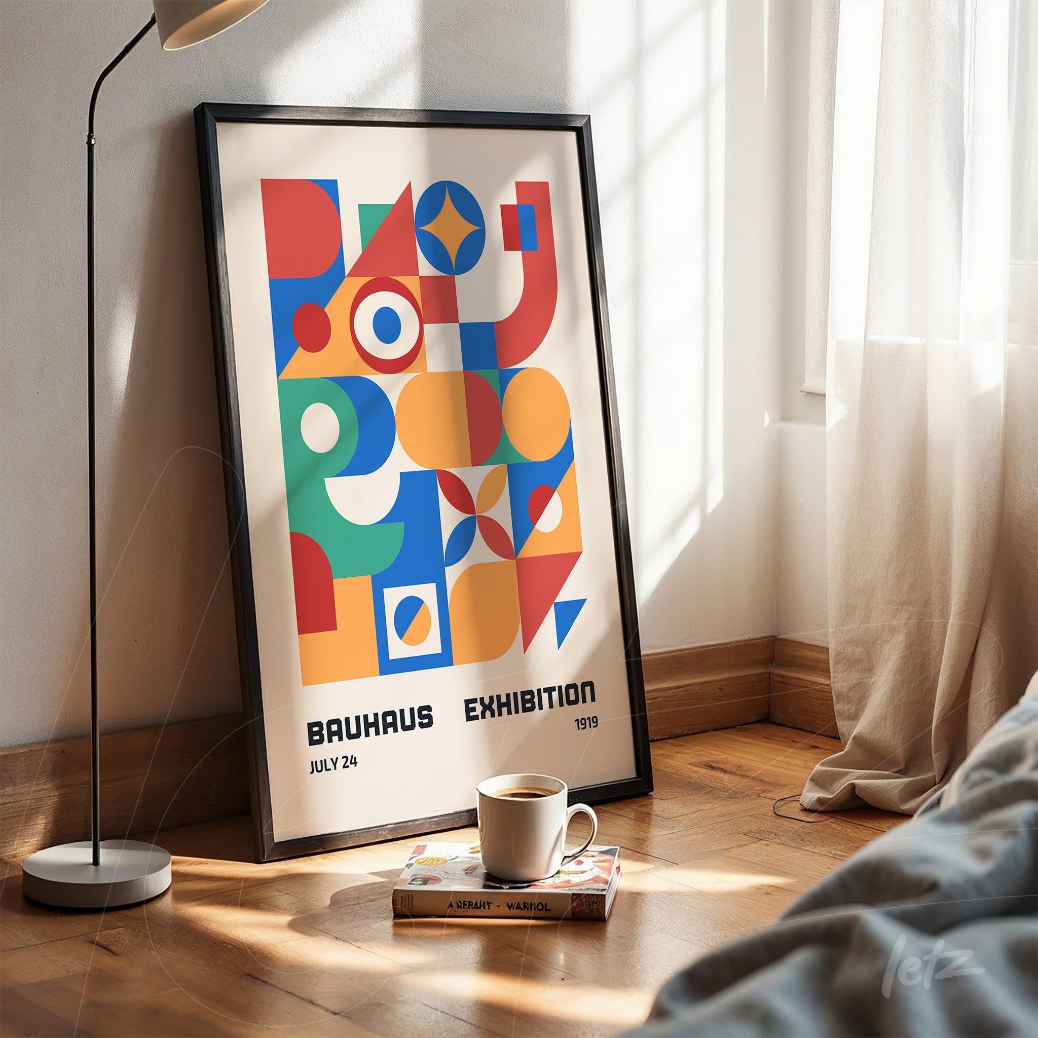 framed art print with colorful geometric bauhaus inspired design resting on wooden floor next to a lamp