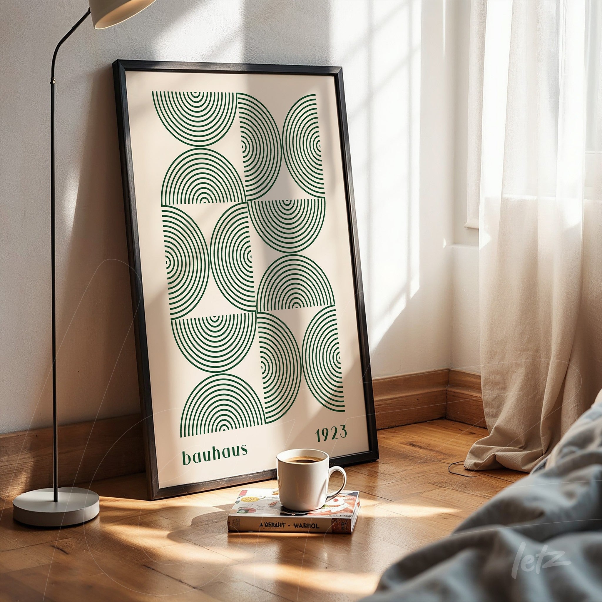 poster print of bauhaus design featuring green concentric circles in black frame, propped on wooden floor