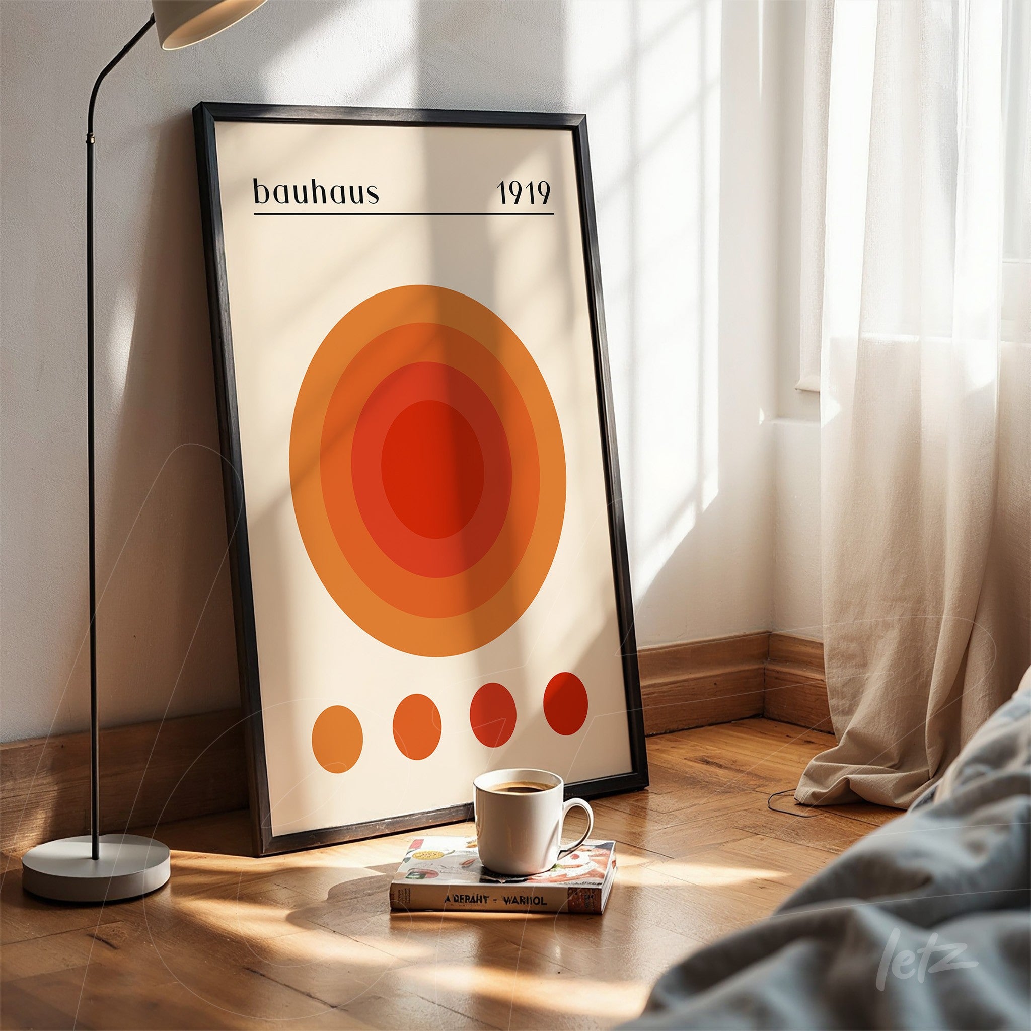 modern poster art of concentric circles in shades of orange with black frame leaning on wooden floor