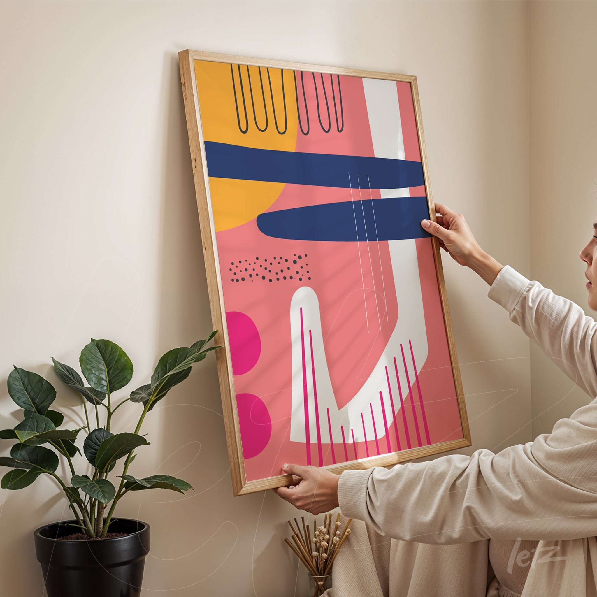 quadro boho moderno com formas geométricas coloridas em moldura de madeira clara apoiado em parede bege