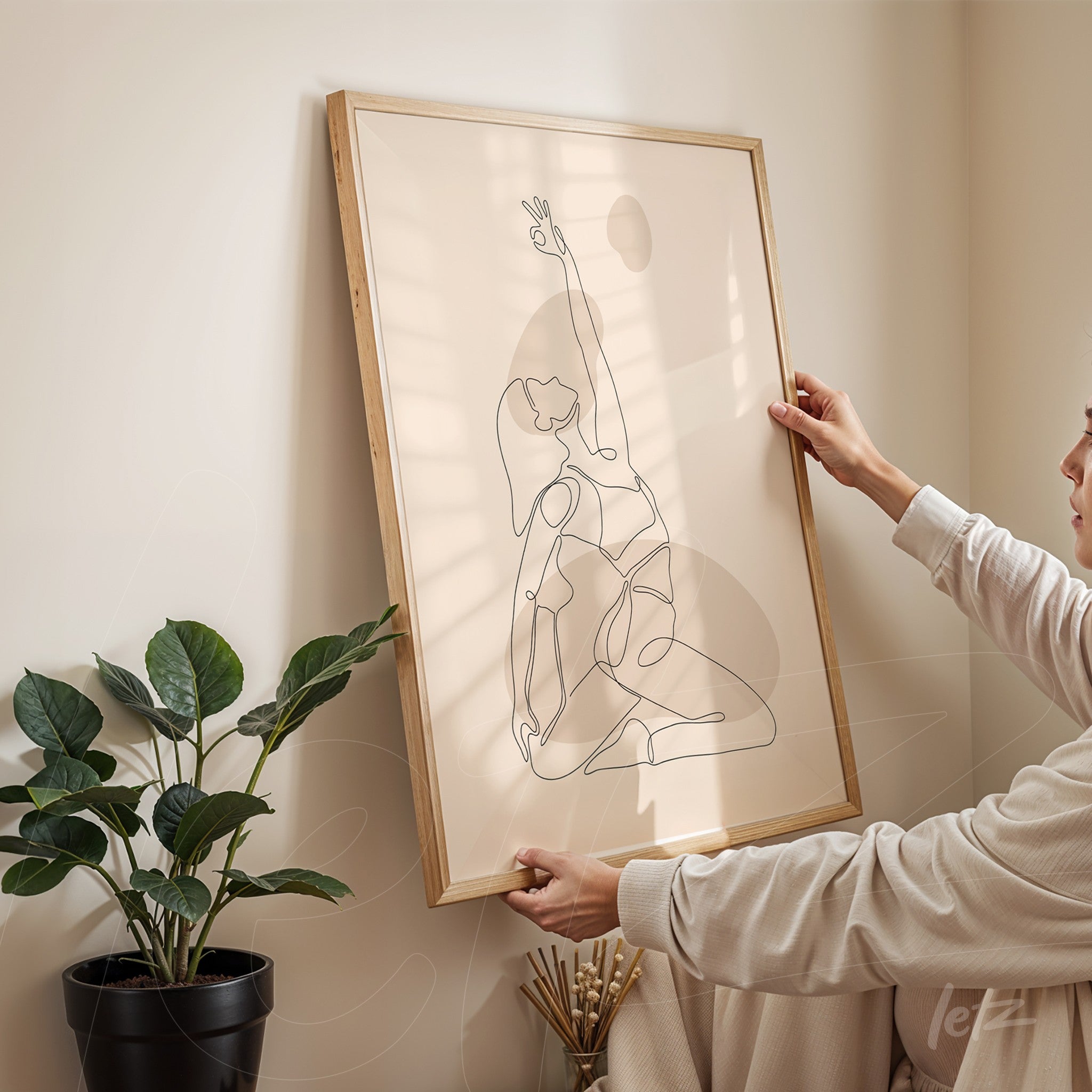 minimalist line art of a seated female figure in black outline framed with light wood, being placed on a beige wall beside a green plant in a black pot