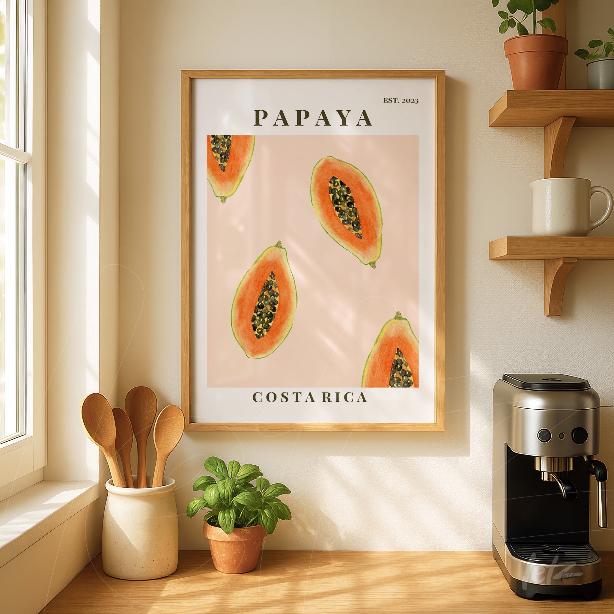 framed artwork of papayas on a pink background with light wood frame displayed in a bright kitchen setting