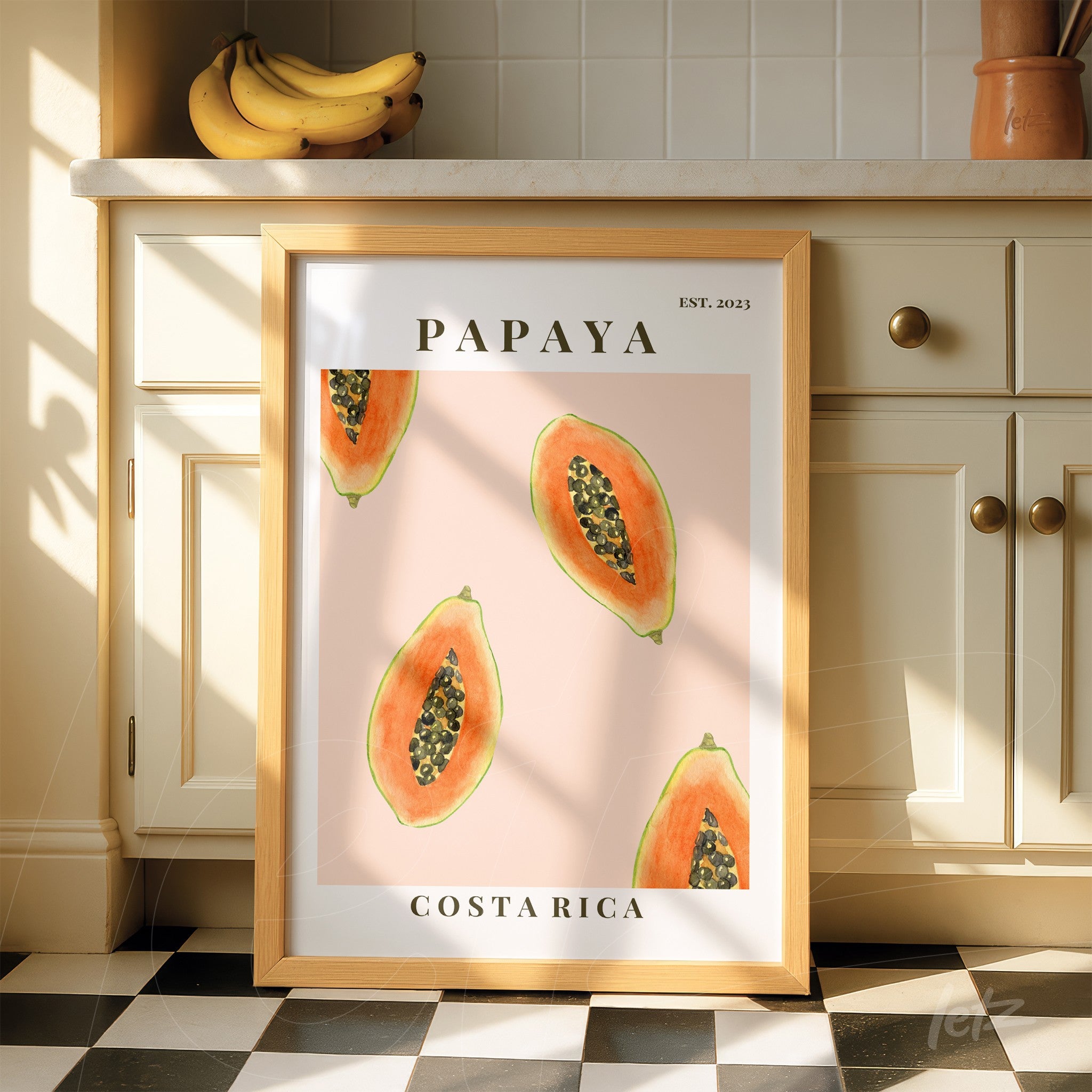 framed artwork featuring papayas on a pink background with light wood frame and text 'PAPAYA' and 'COSTA RICA'