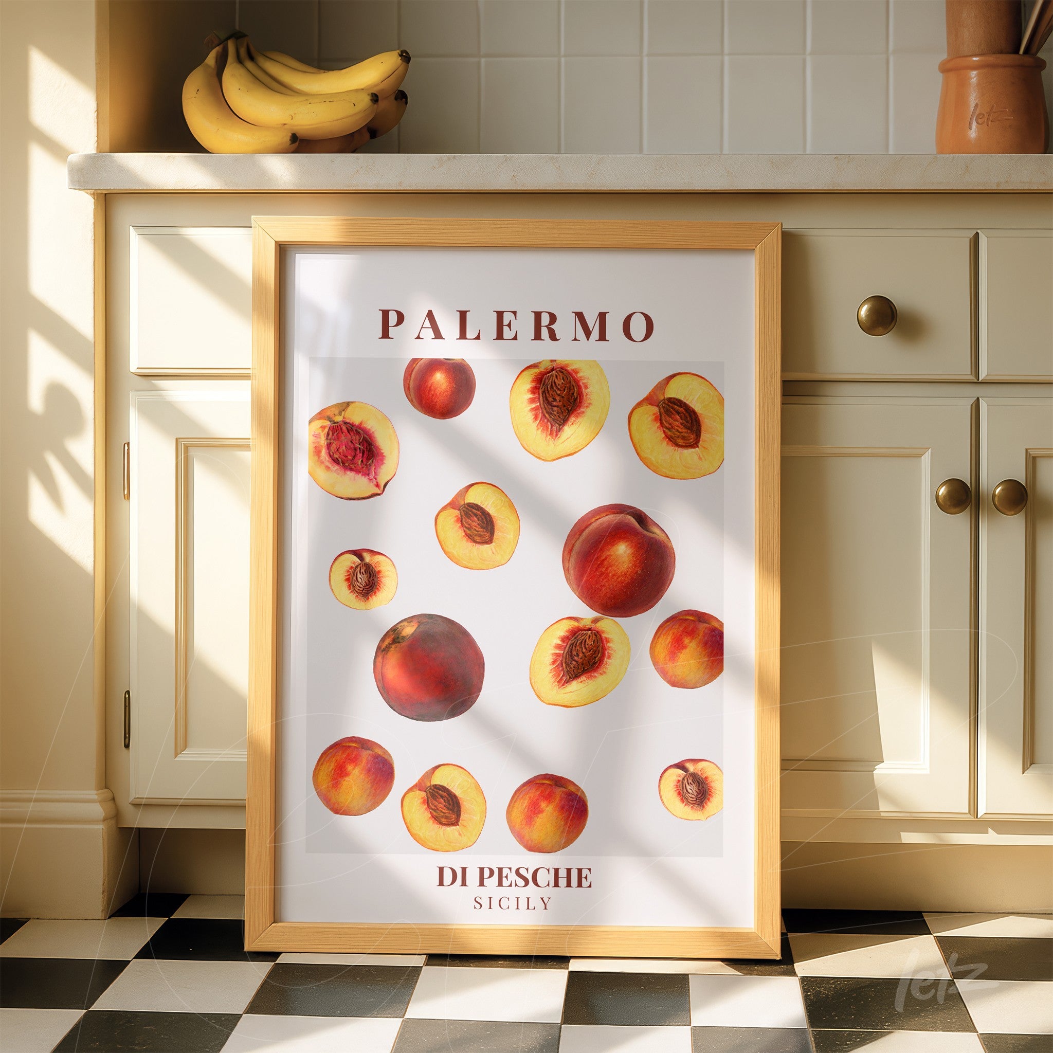 framed art print featuring peaches in light wood frame displayed in a sunlit kitchen
