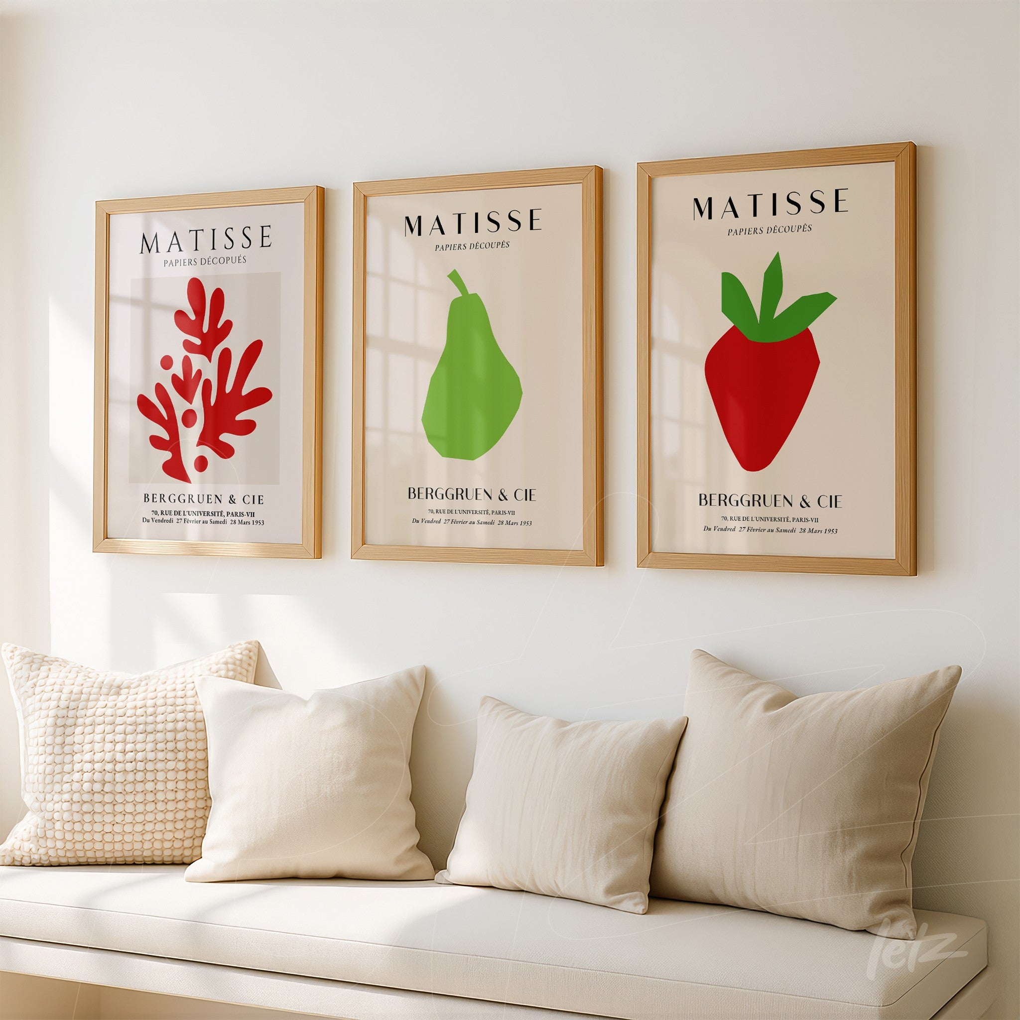 composition of three framed wall art pieces featuring modern style illustrations of a red coral, a green pear, and a red strawberry, all in light wood frames with a neutral background