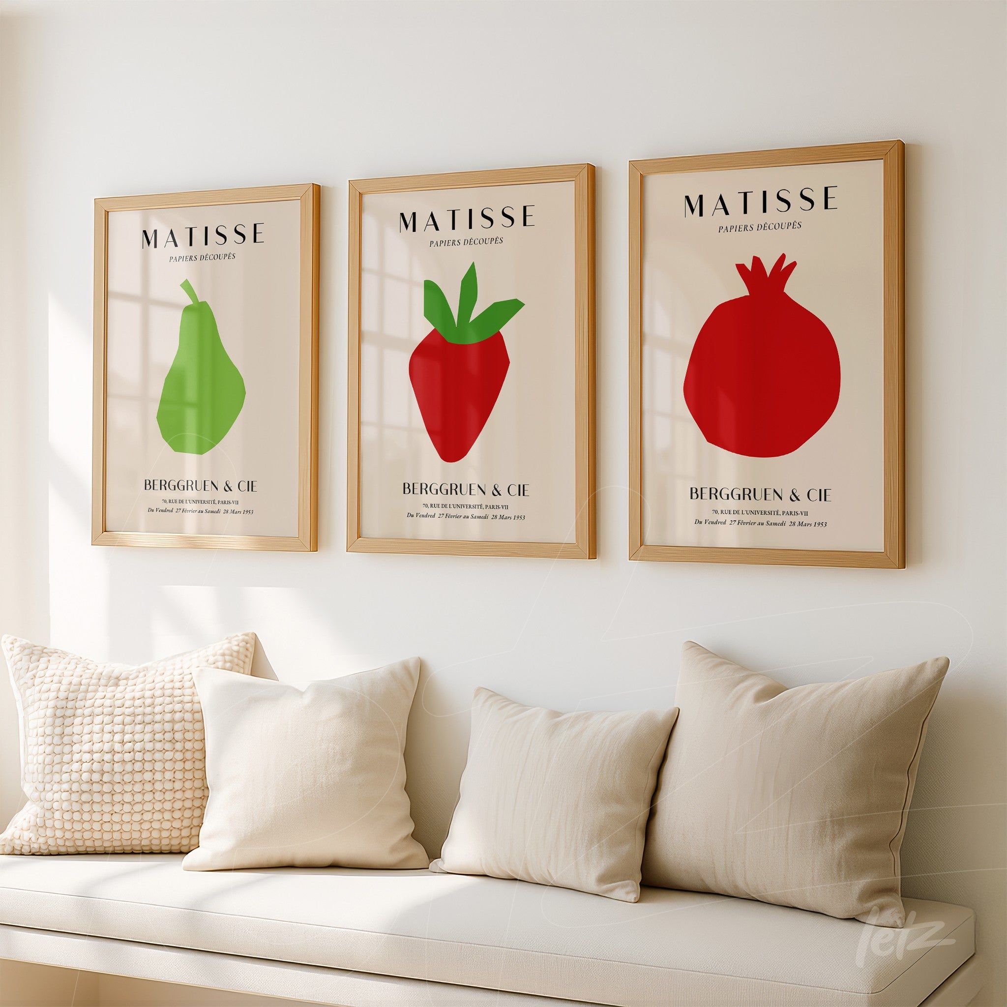 series of framed wall art featuring minimalist fruit illustrations with light wood frames, depicting a green pear, a red strawberry, and a pomegranate on a light wall