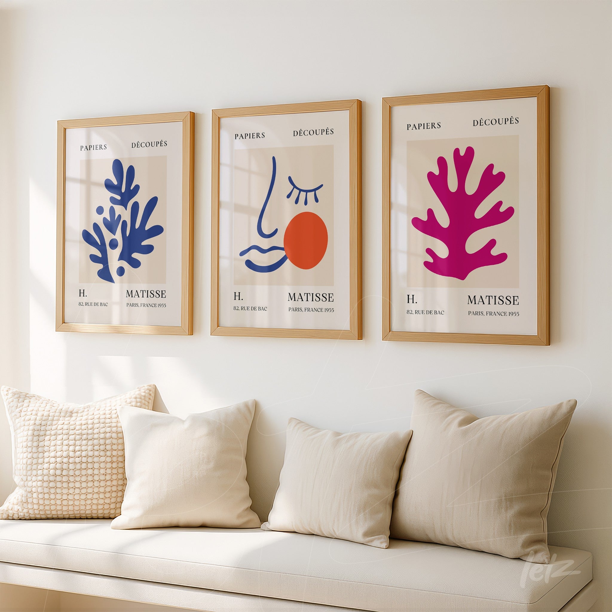 collection of three vibrant wall art pieces in light wood frame featuring abstract coral shapes and a stylized face on a light background