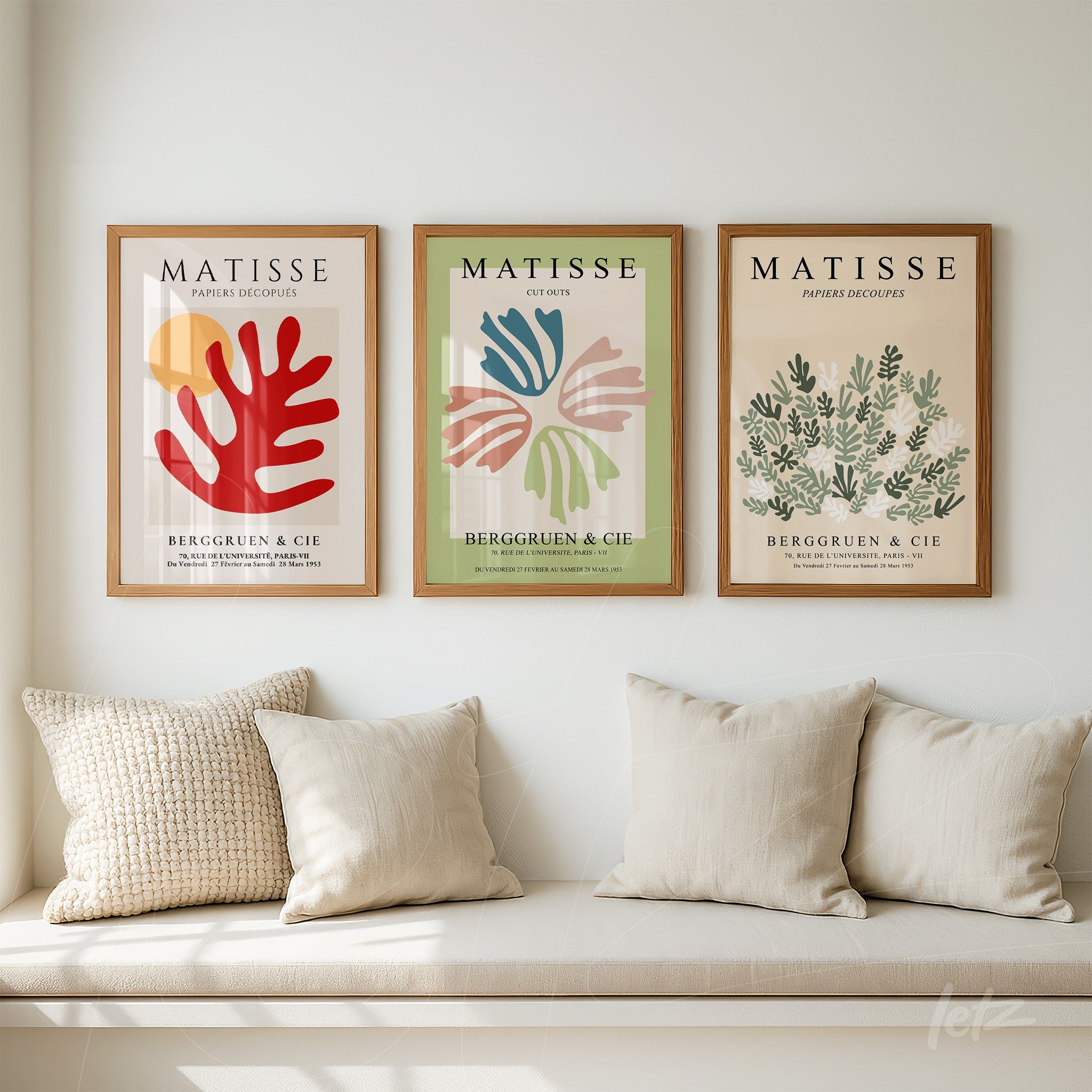 set of three framed decorative artworks inspired by Matisse in light wood frames against a white wall