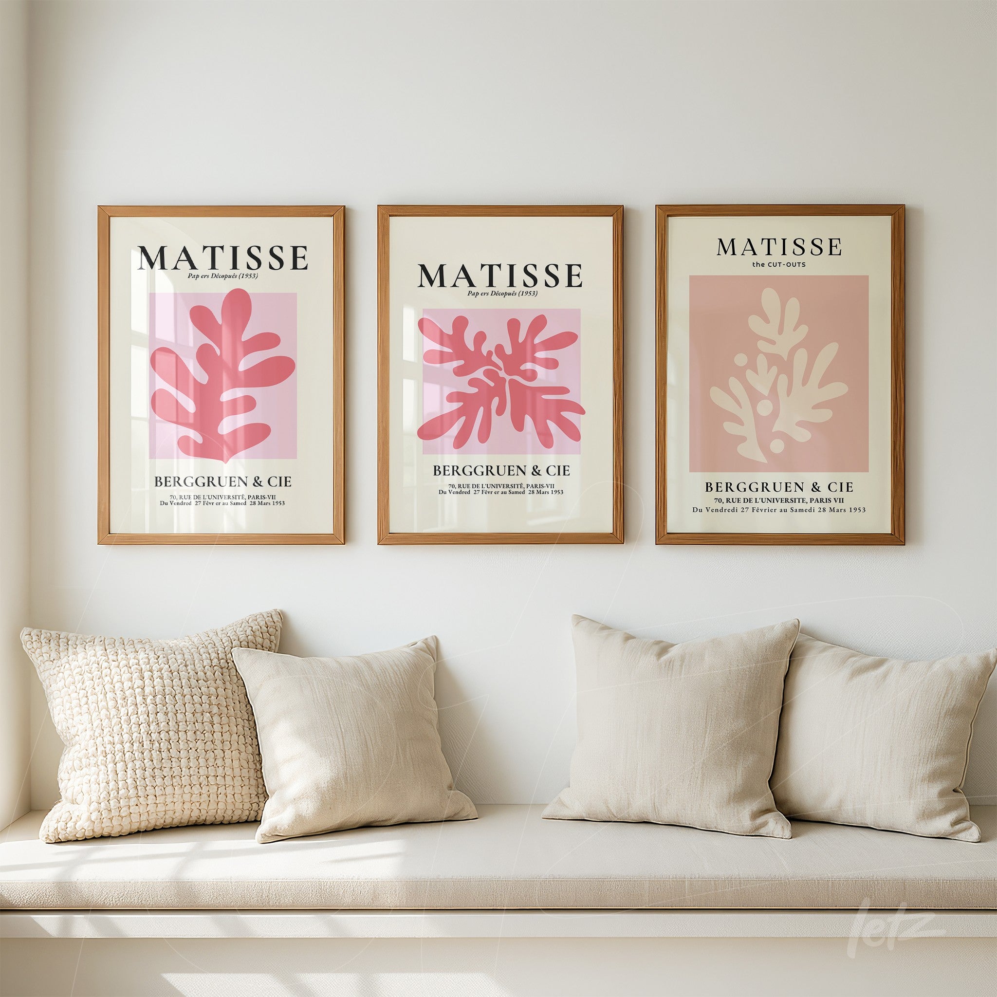 collection of three framed artworks in light wood featuring abstract illustrations in shades of pink and cream with botanical elements