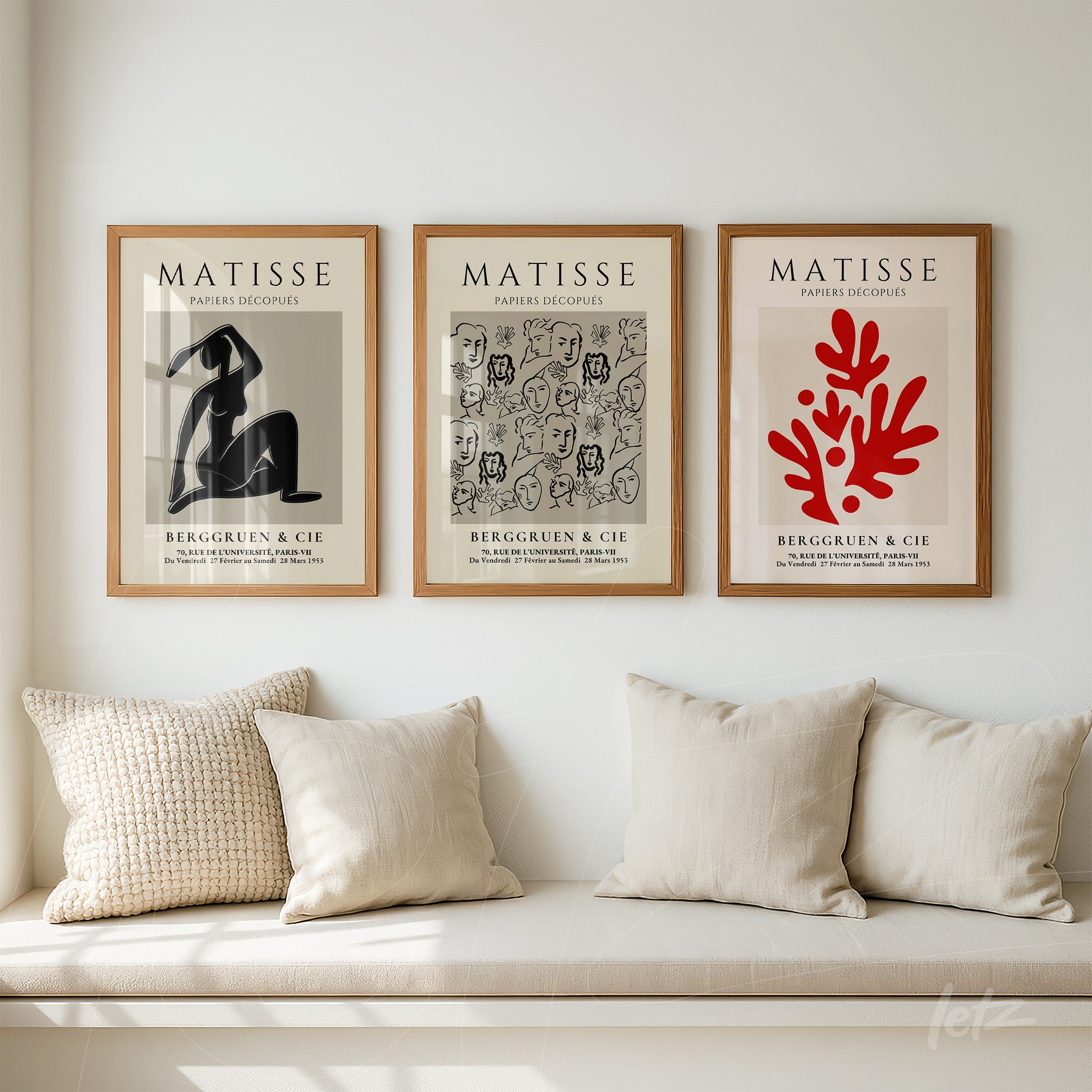 composition of three framed artworks by henri matisse in light wood frames against a light wall, showcasing an abstract figure, a series of faces, and a red coral design